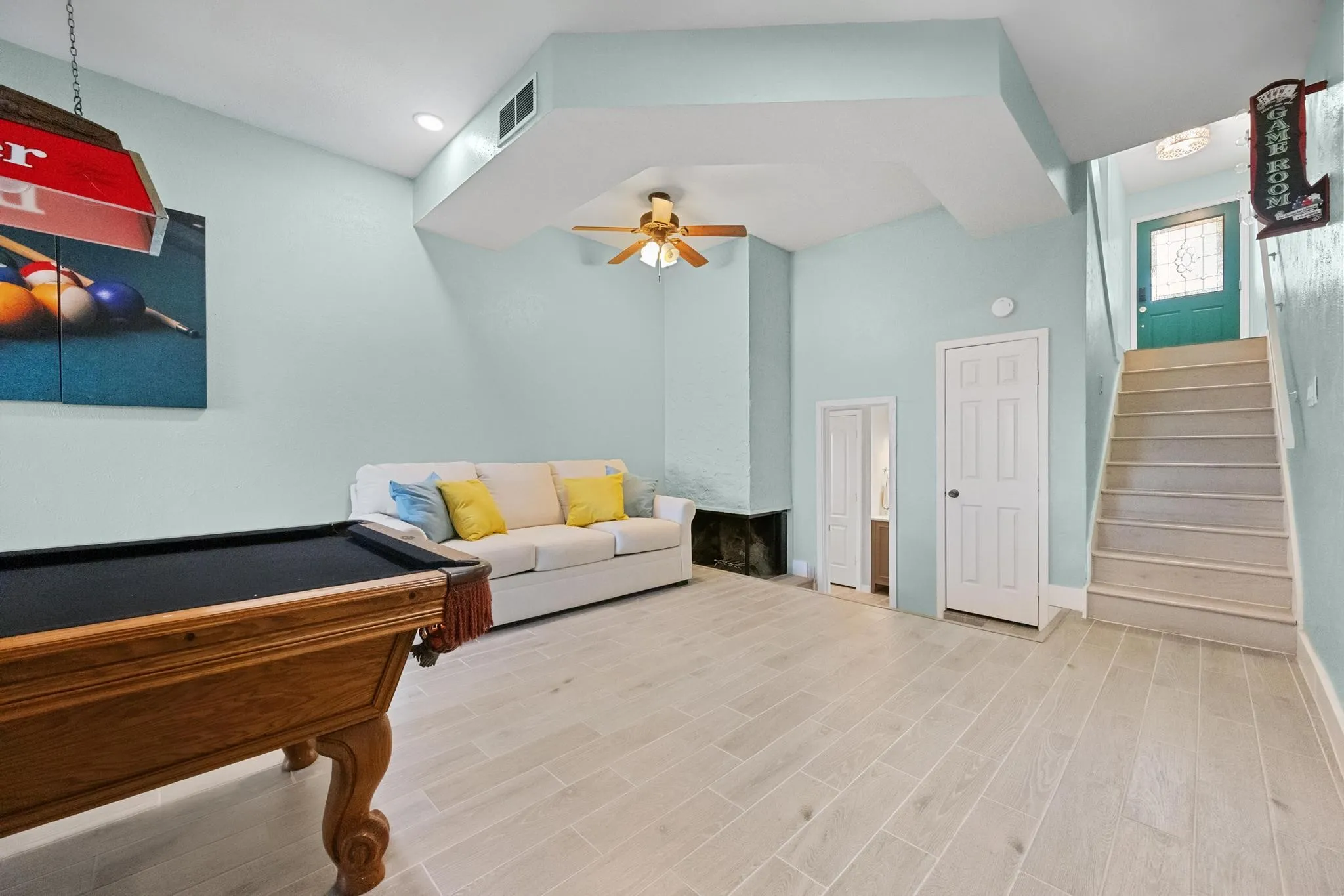 Light-toned wood-finish flooring, recessed ceiling lighting, and a ceiling fan
