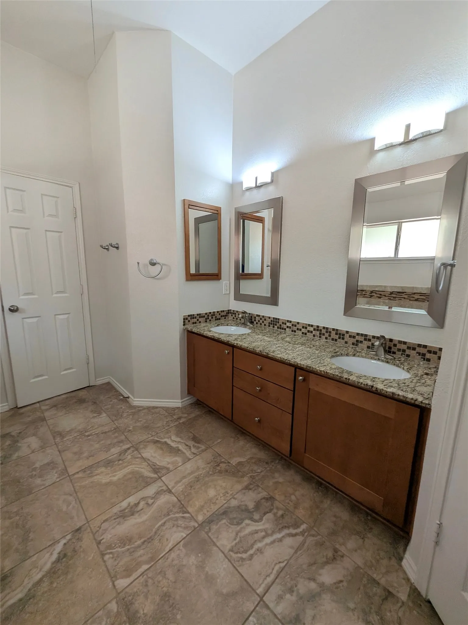 Dual vanity with granite countertops, undermount sinks, and wood cabinetry