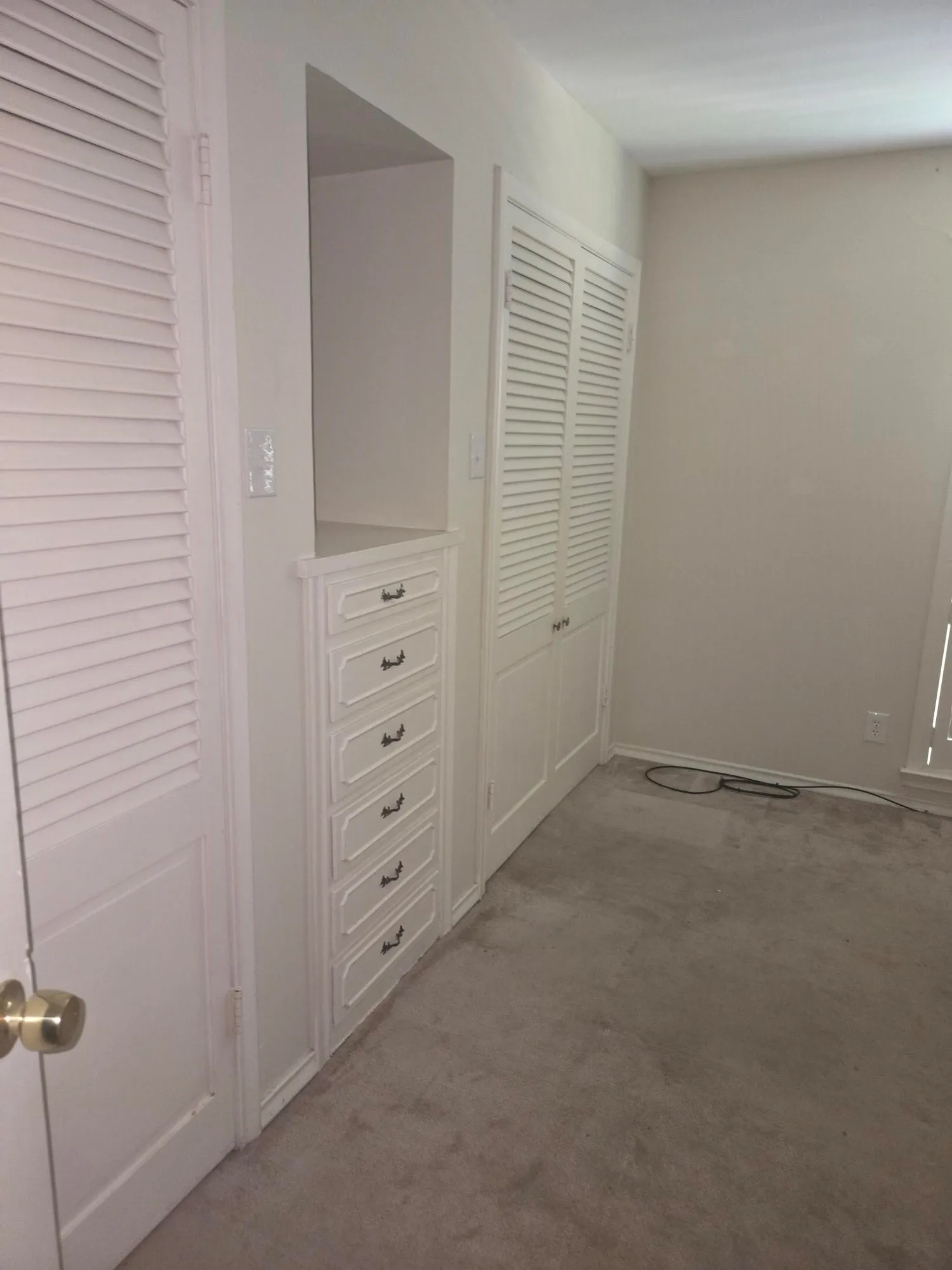 Built-in cabinetry with six drawers, recessed shelving, and louvered closet doors