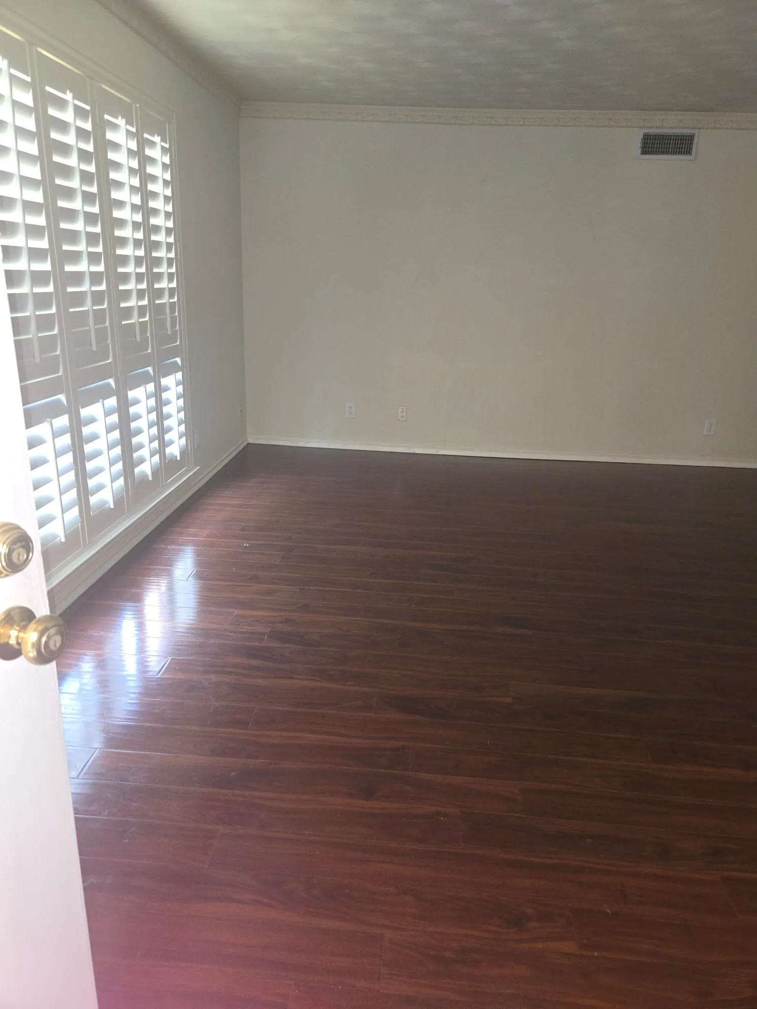 Wood-finish flooring throughout, bright white walls, and elegant crown molding