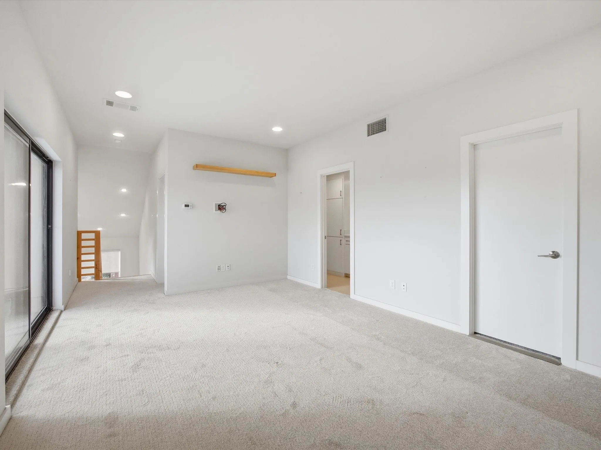 Unfurnished bedroom with light carpet, recessed lighting, and ensuite bathroom