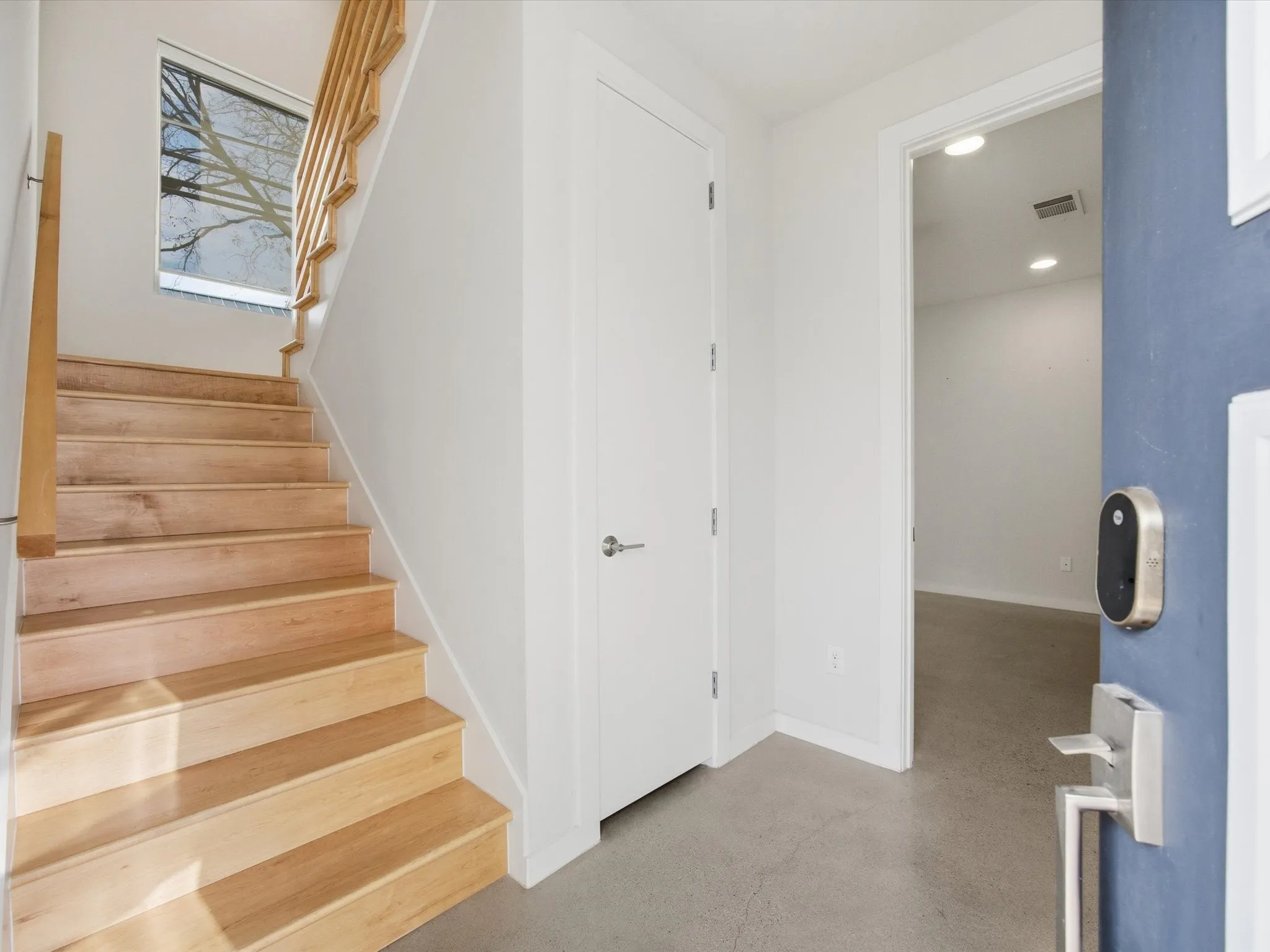 Stairs with recessed lighting and finished concrete floors