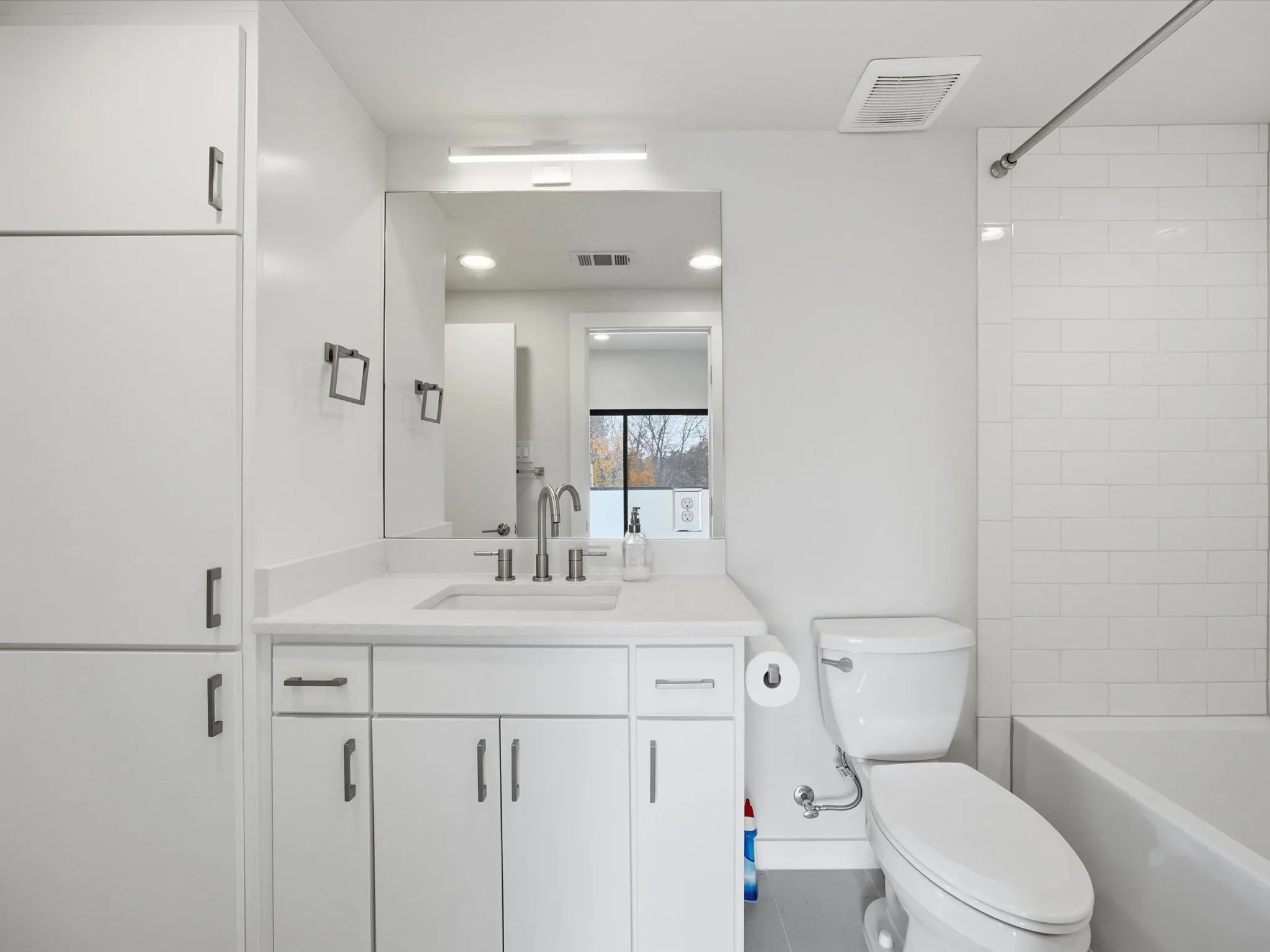 Bathroom featuring vanity, shower / bath combination, and tile patterned flooring