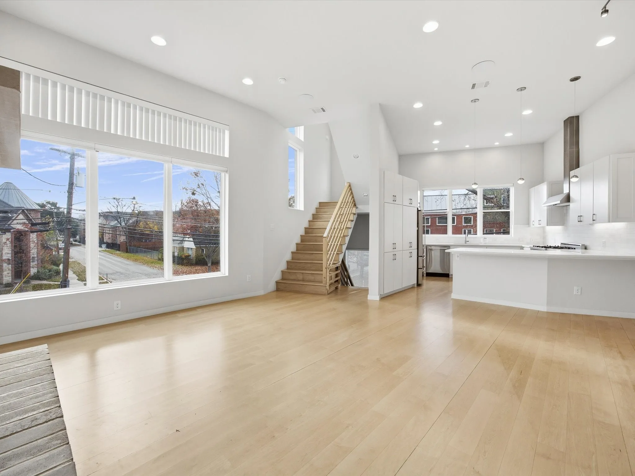 Unfurnished living room featuring stairs, light wood-style flooring, and recessed lighting