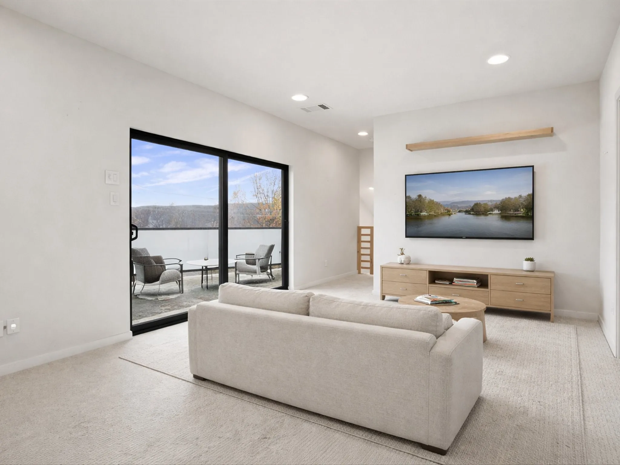 Living room with light colored carpet and recessed lighting