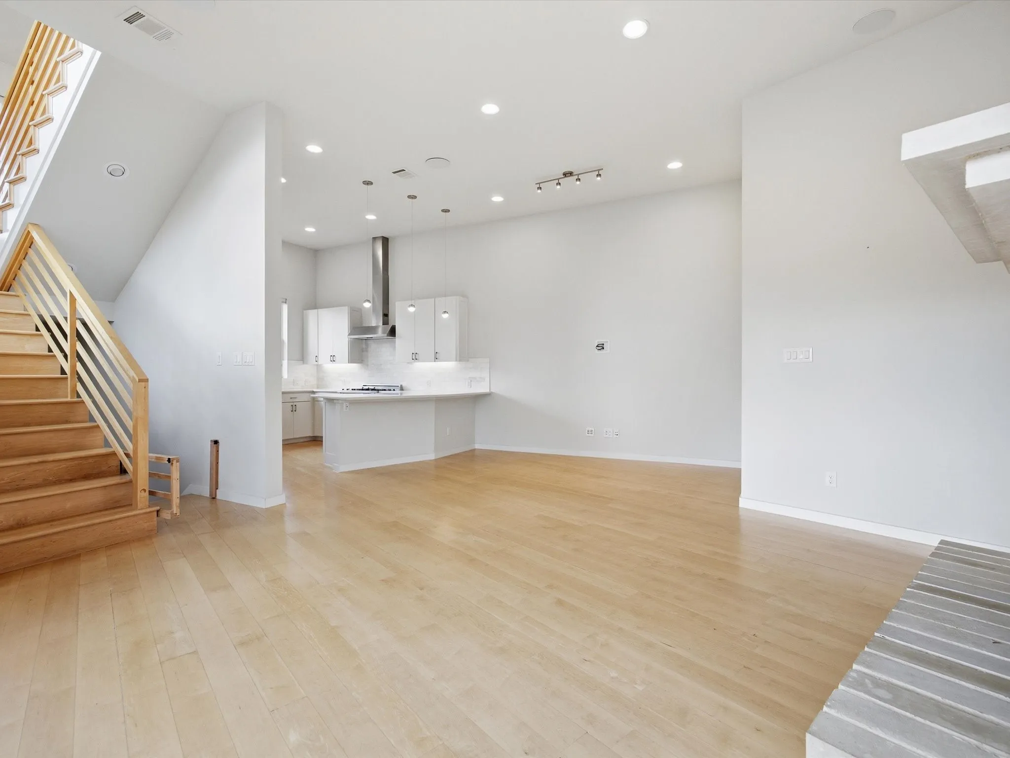 Unfurnished living room featuring stairs, recessed lighting, and light wood-type flooring