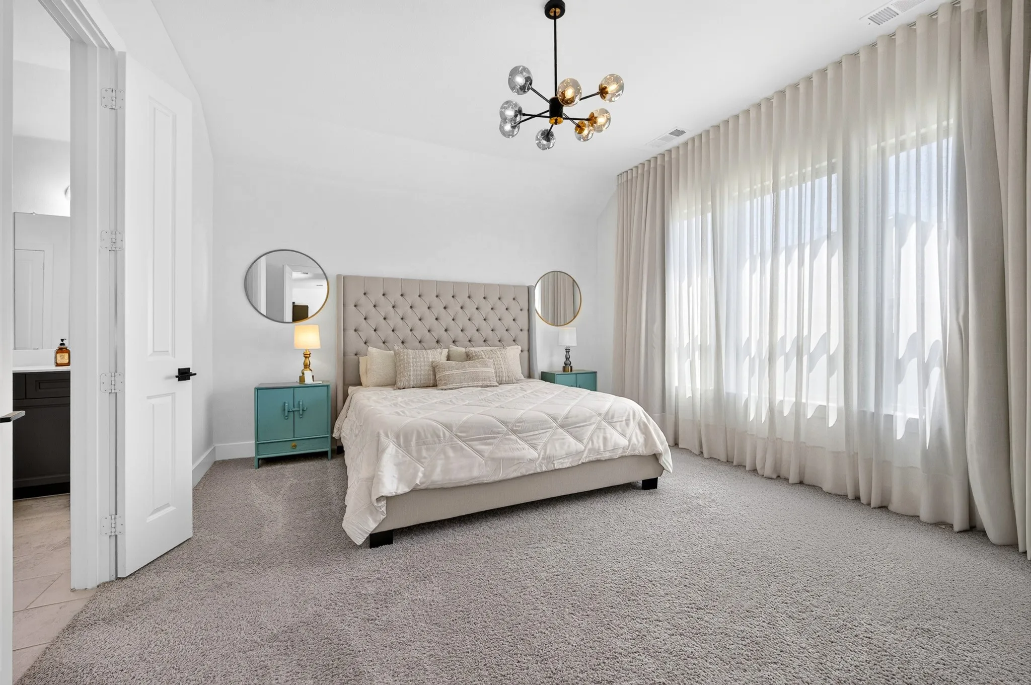 White interior walls with a contemporary chandelier and wall-to-wall carpeting