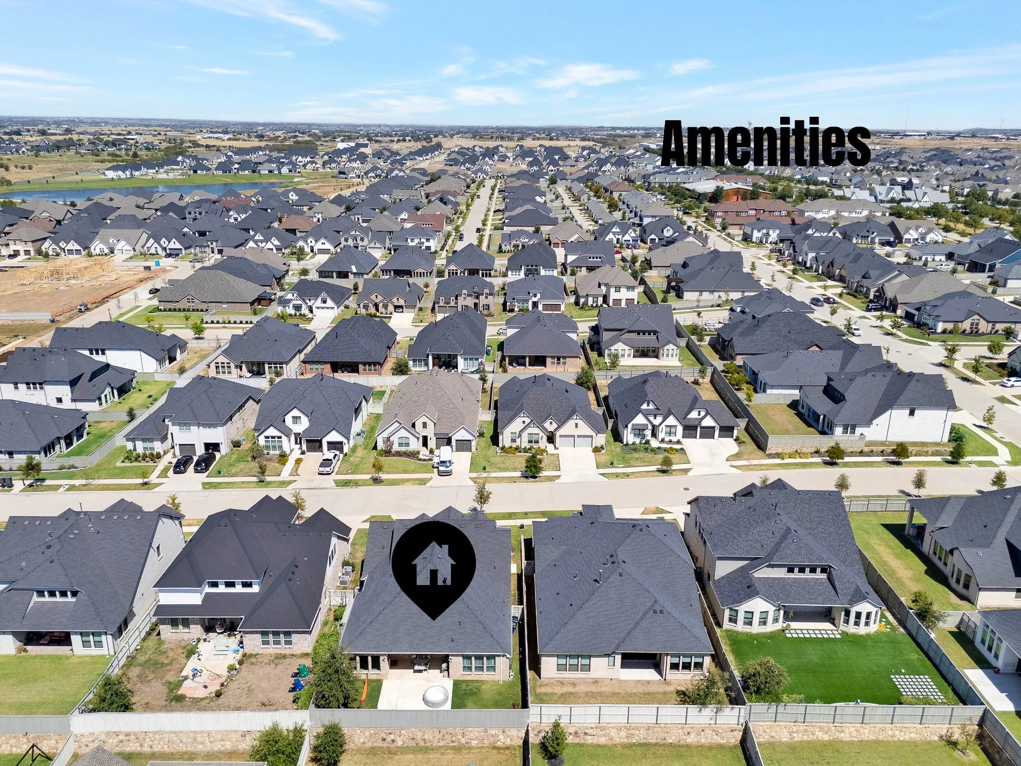 Aerial perspective of a developed residential community featuring numerous single-family homes with dark-toned roofs