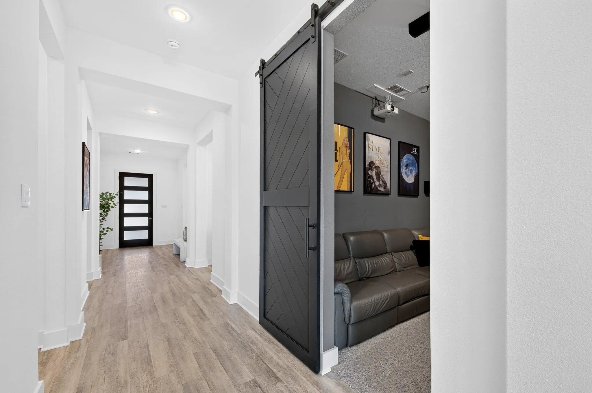 Hallway with wood-finish flooring, recessed lighting, and a modern black barn door