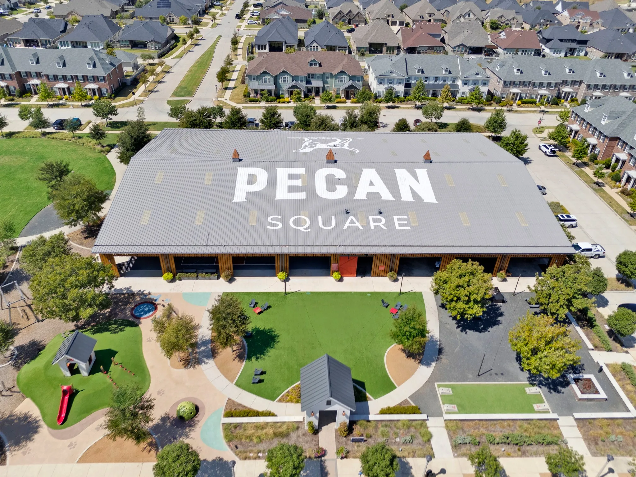 Large-scale building with a metal roof and prominent branding, surrounded by residential properties