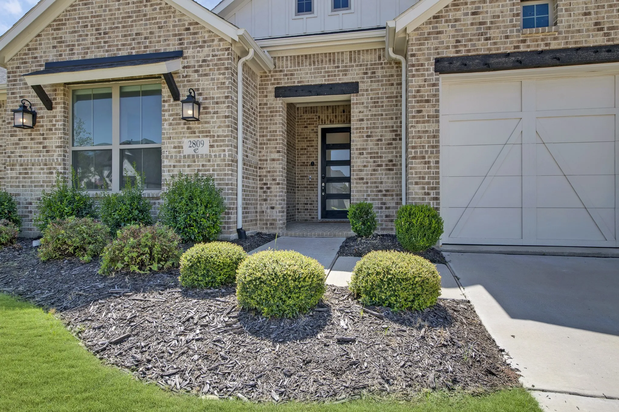 Brick exterior with white siding accents and a covered entryway
