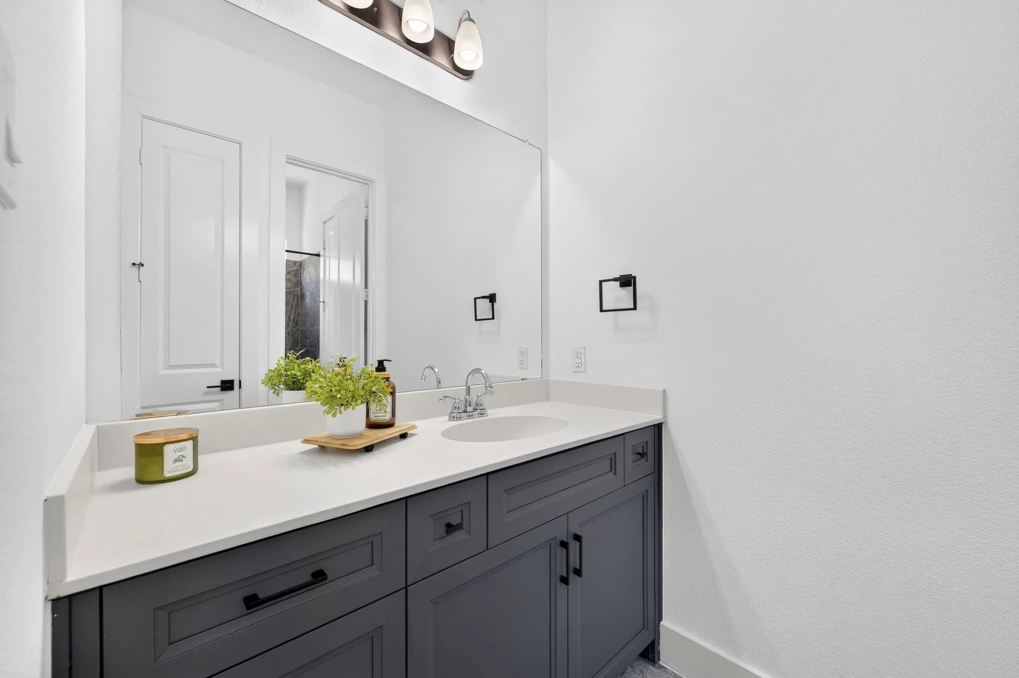 Spacious vanity with a white countertop, undermount sink, and dark gray cabinetry