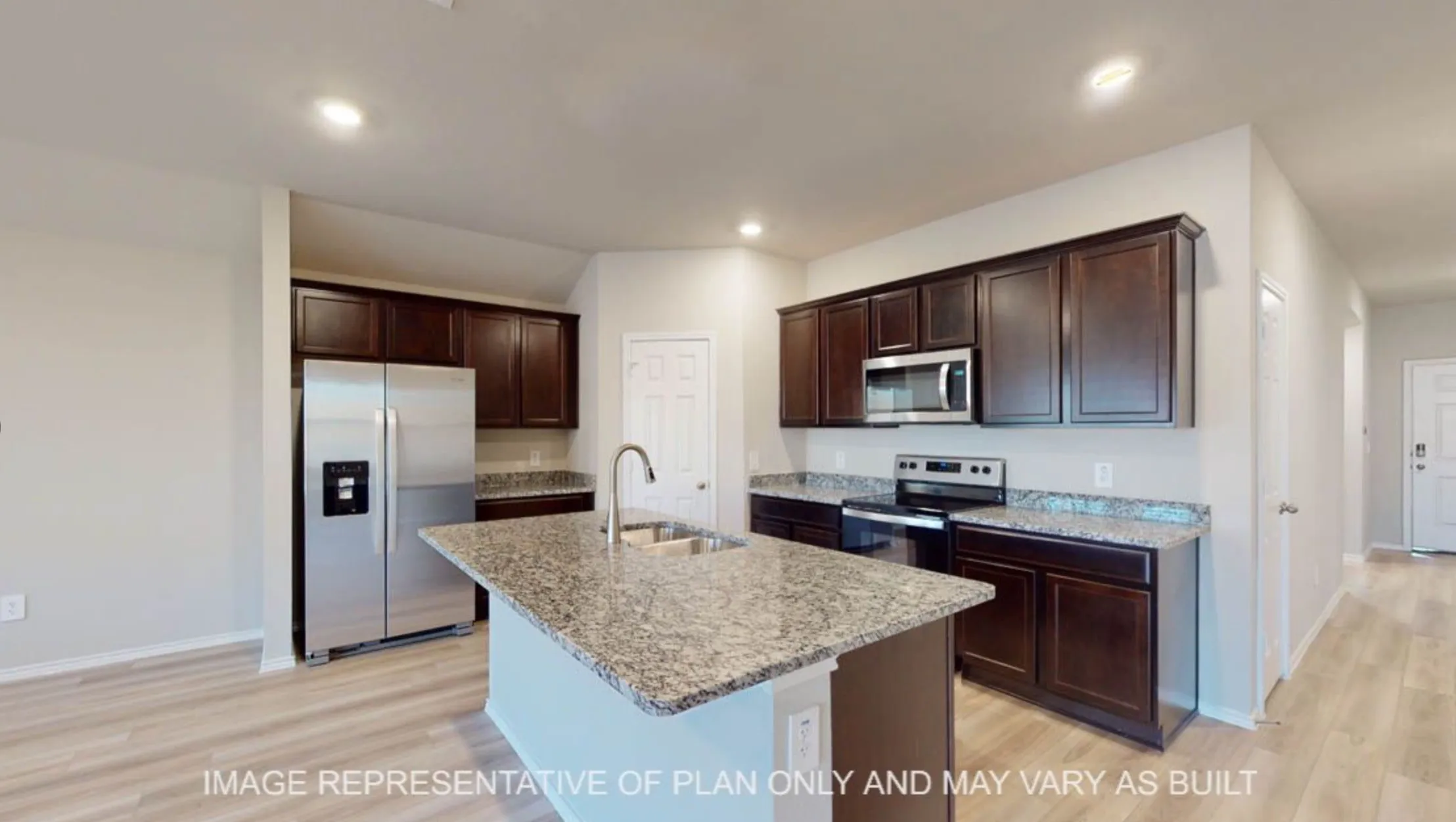 Open-concept kitchen featuring an island with a double basin sink, dark wood-finish cabinetry, stainless steel appliances, and granite countertops