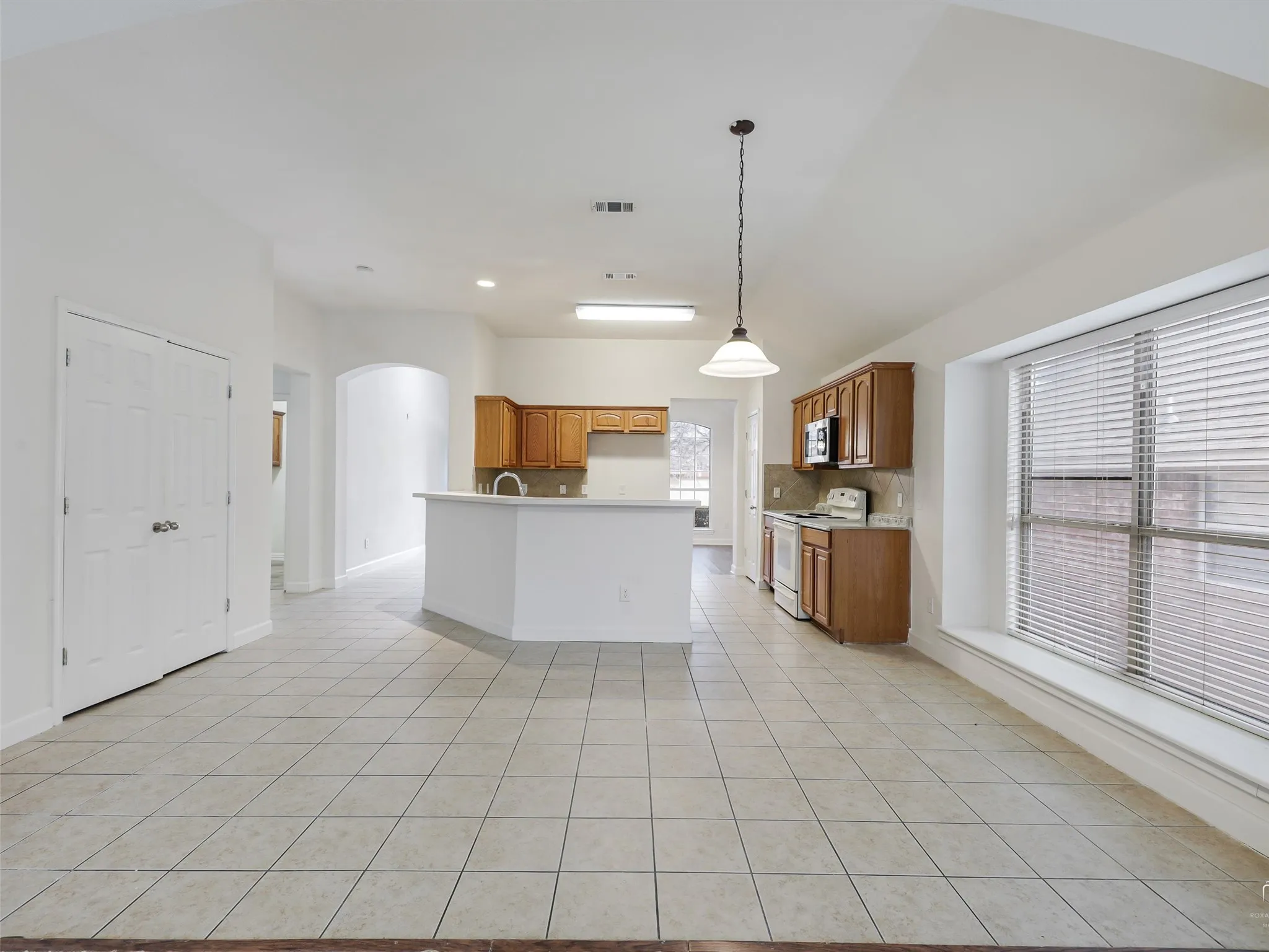 Vaulted ceiling with an overhead light fixture and pendant lighting