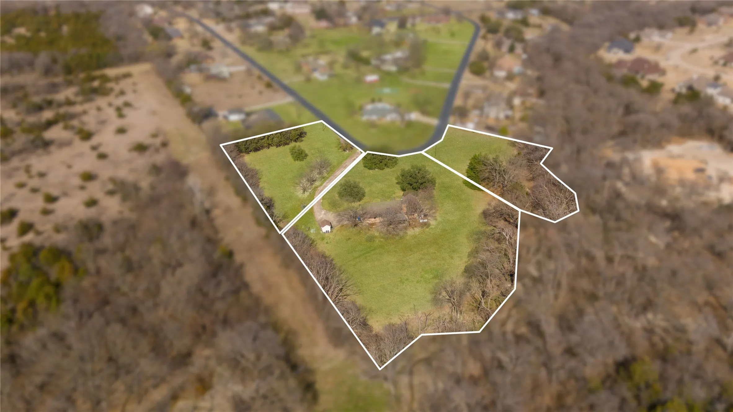 Expansive lot featuring a green pasture, mature trees, and defined property lines