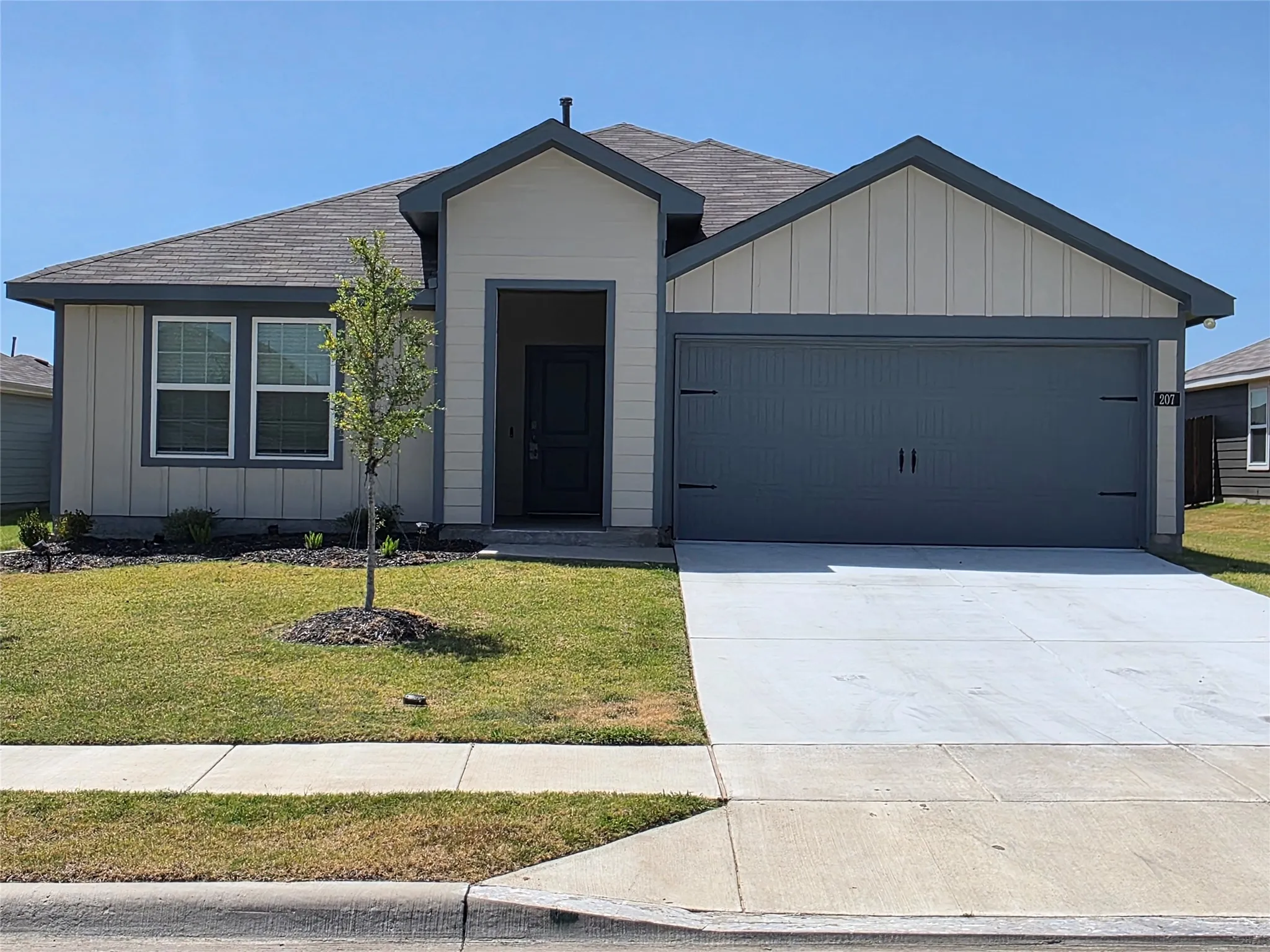 Contemporary exterior with vertical siding accents, an attached two-car garage, and a concrete driveway