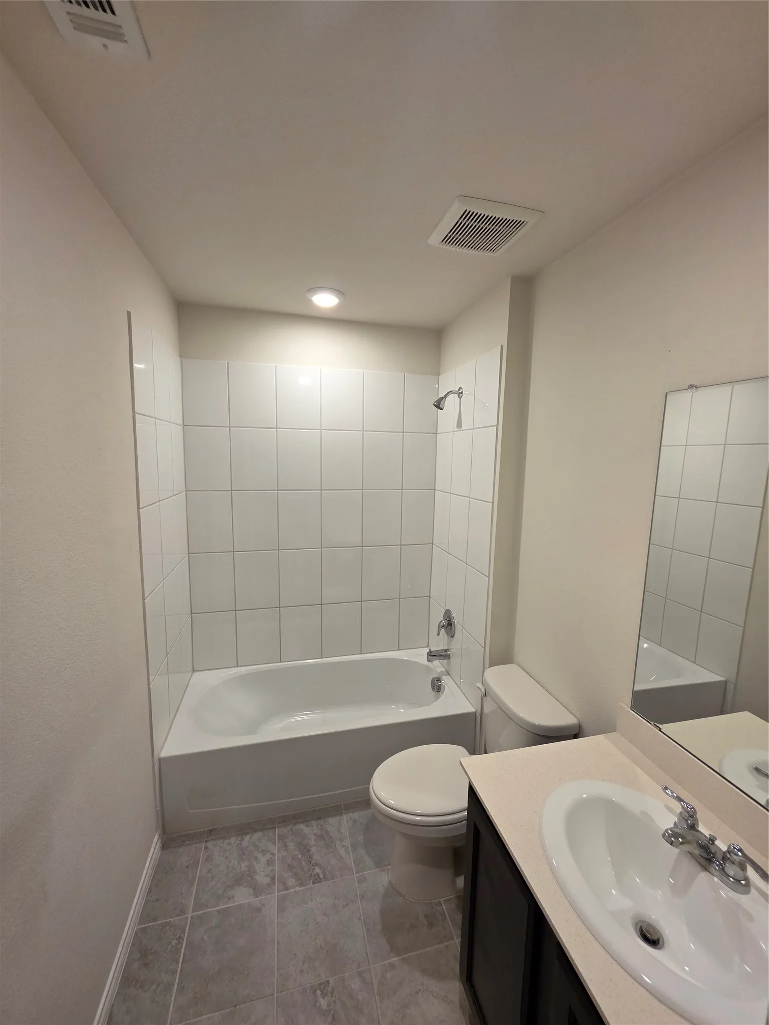 Contemporary bathroom featuring a tile-enclosed soaking tub with chrome fixtures, an elongated toilet, a pedestal sink with single-handle faucet, recessed ceiling lighting, and polished concrete flooring