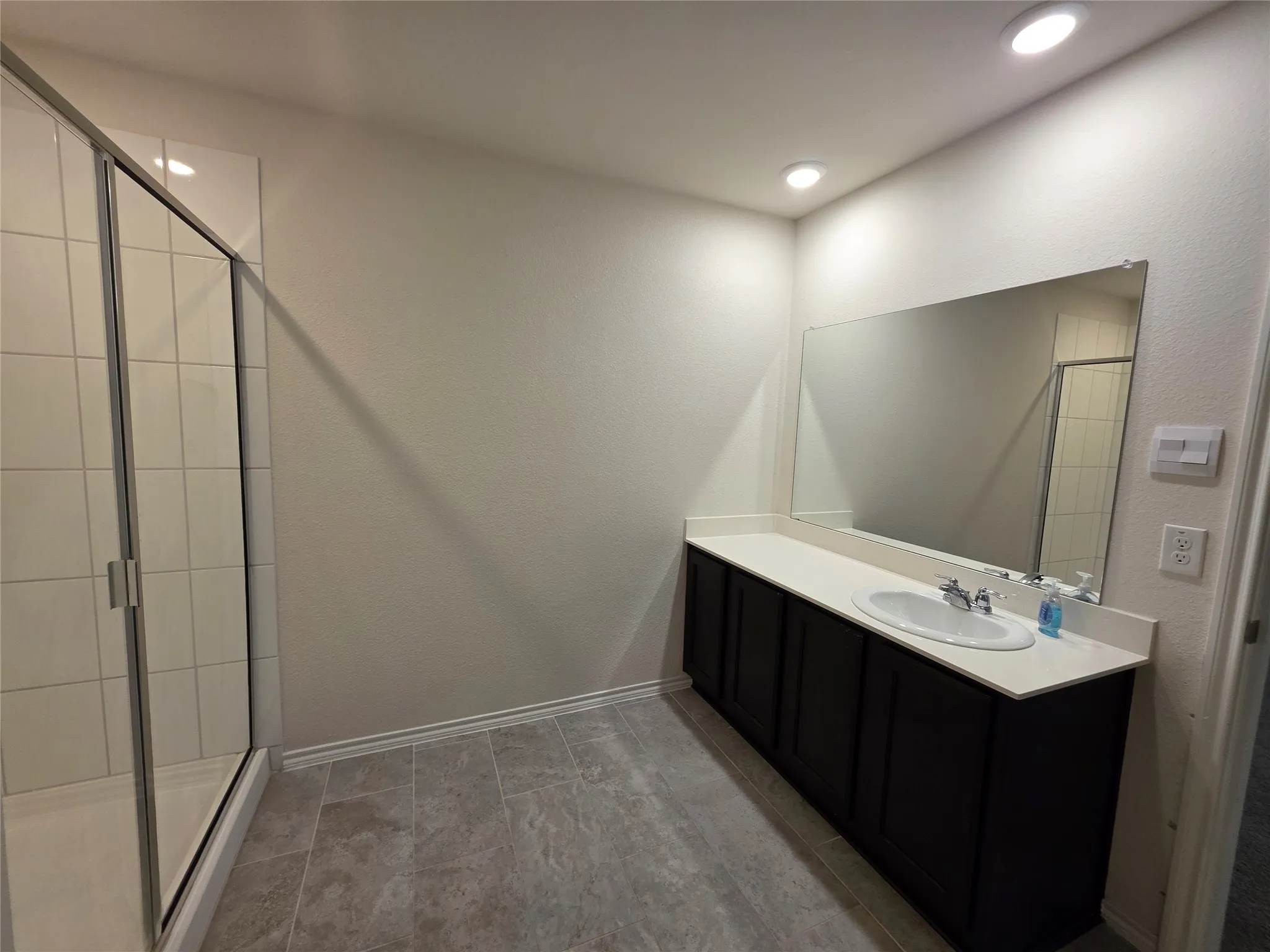 Spacious vanity with a single basin sink, extensive countertop, and integrated mirror