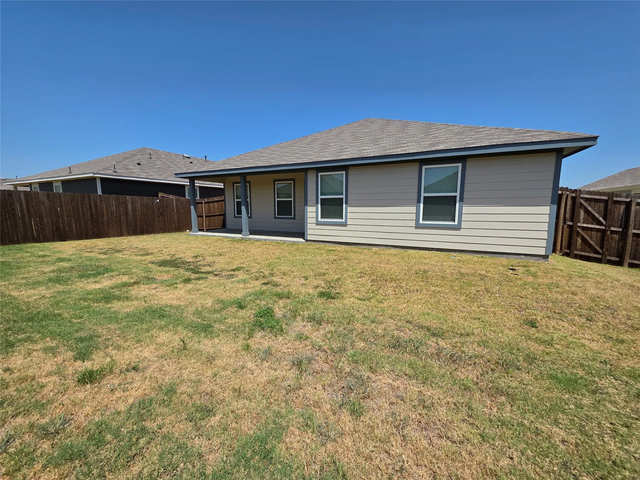 Rear exterior featuring a covered patio, siding, and fenced yard