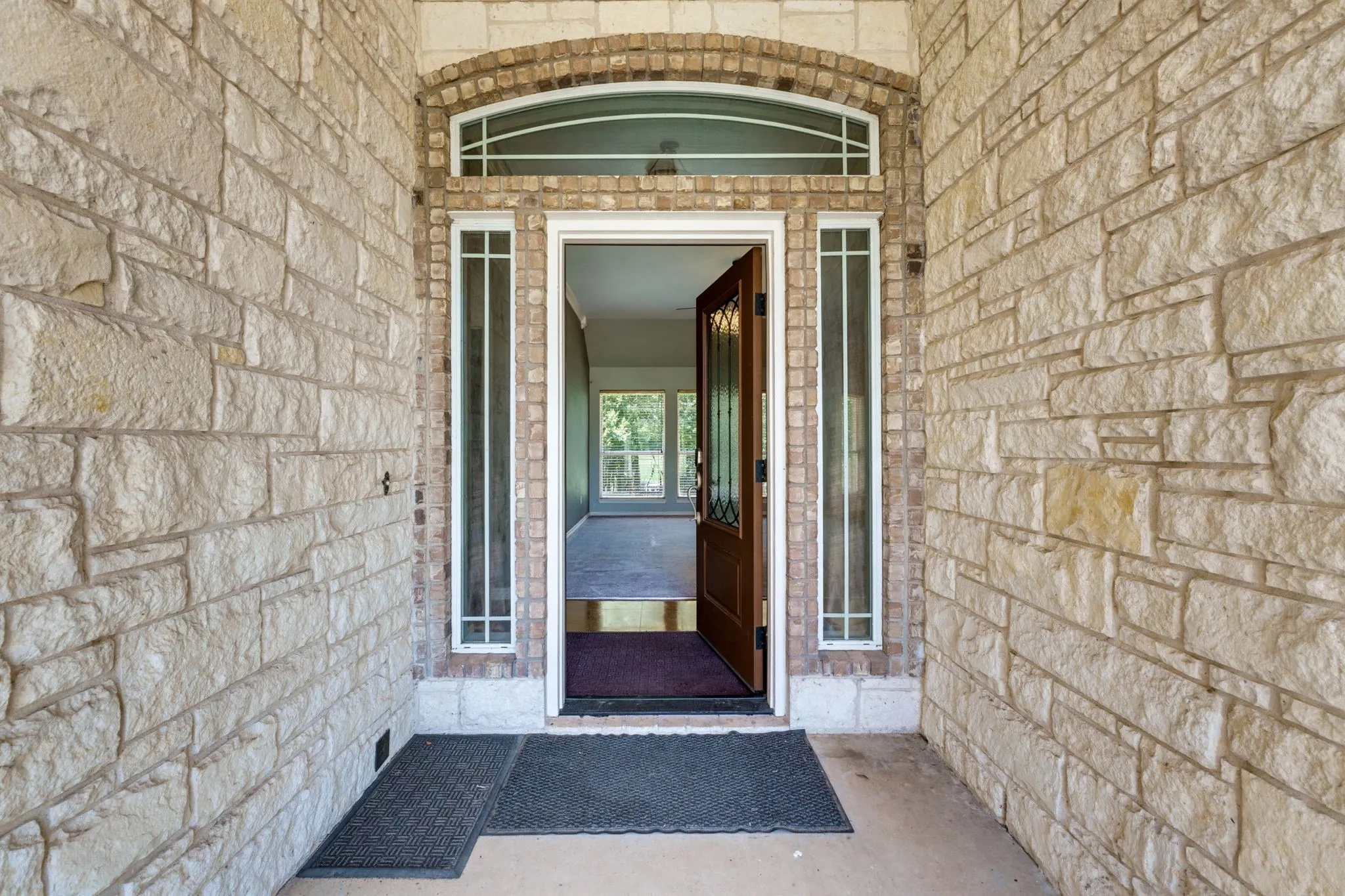Stone-clad exterior featuring an arched brick entryway