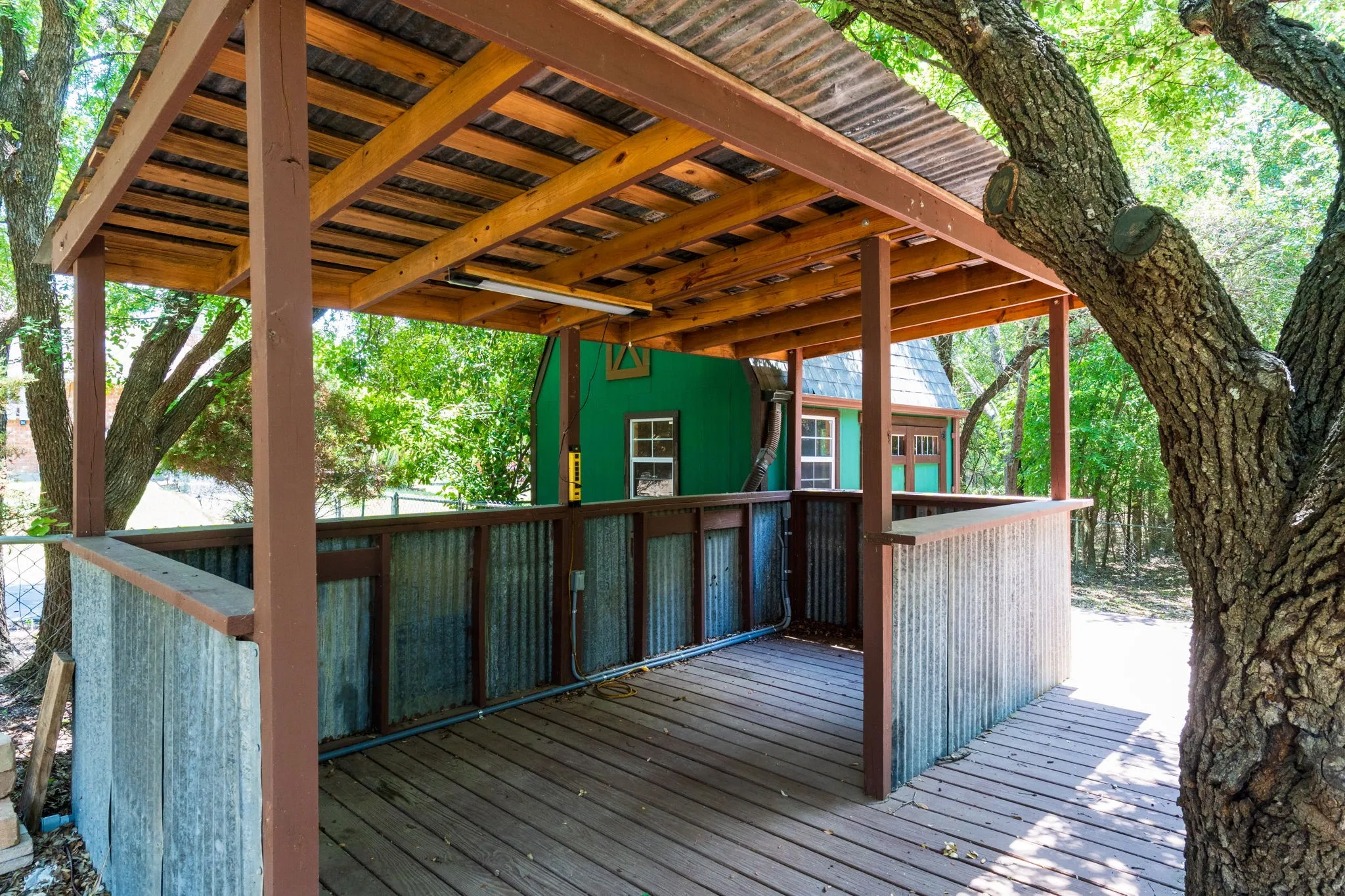 Covered outdoor structure with a corrugated metal roof and wood frame