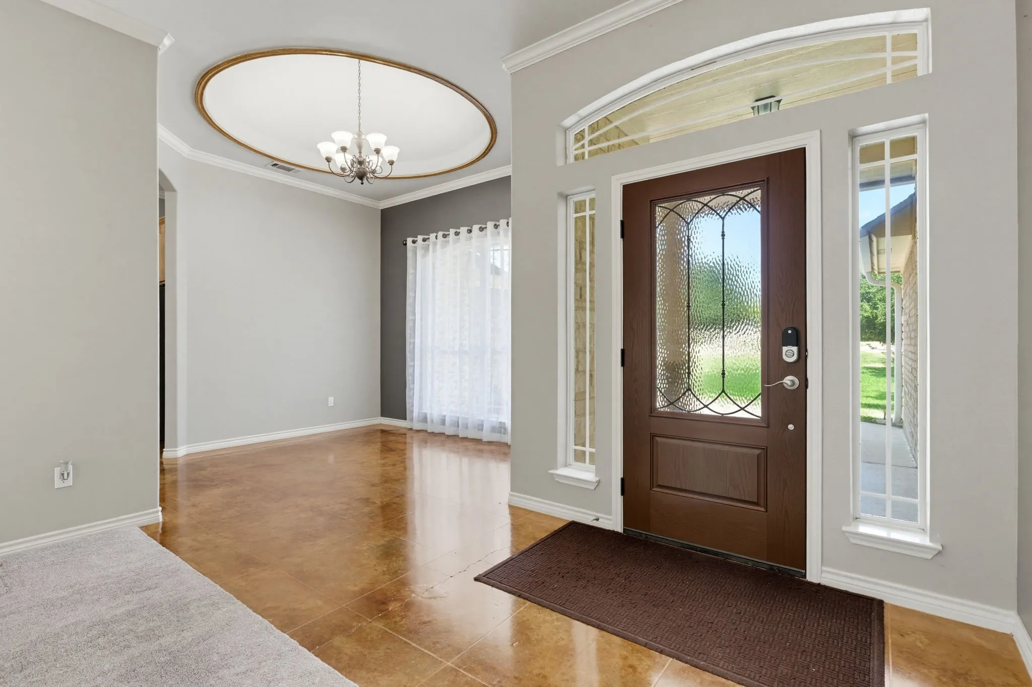 Front entry with a decorative glass-paneled door, arched transom window, and two sidelight windows