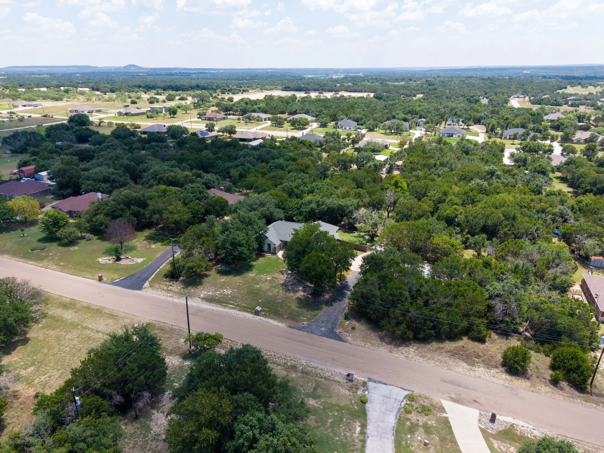 Extensive treed landscape featuring multiple residential properties and paved roadways