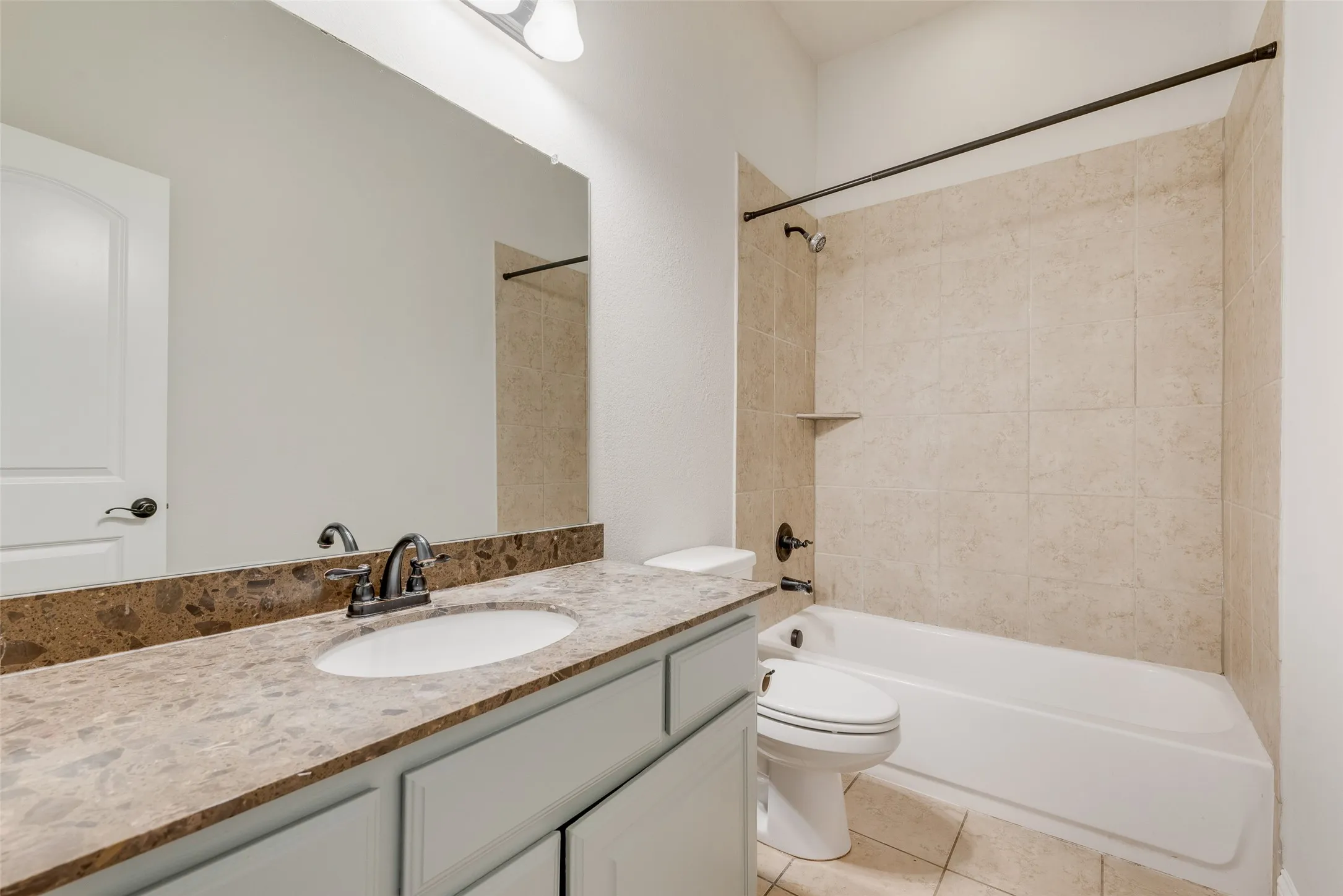 Vanity with an integrated sink, granite countertop, and tiled backsplash