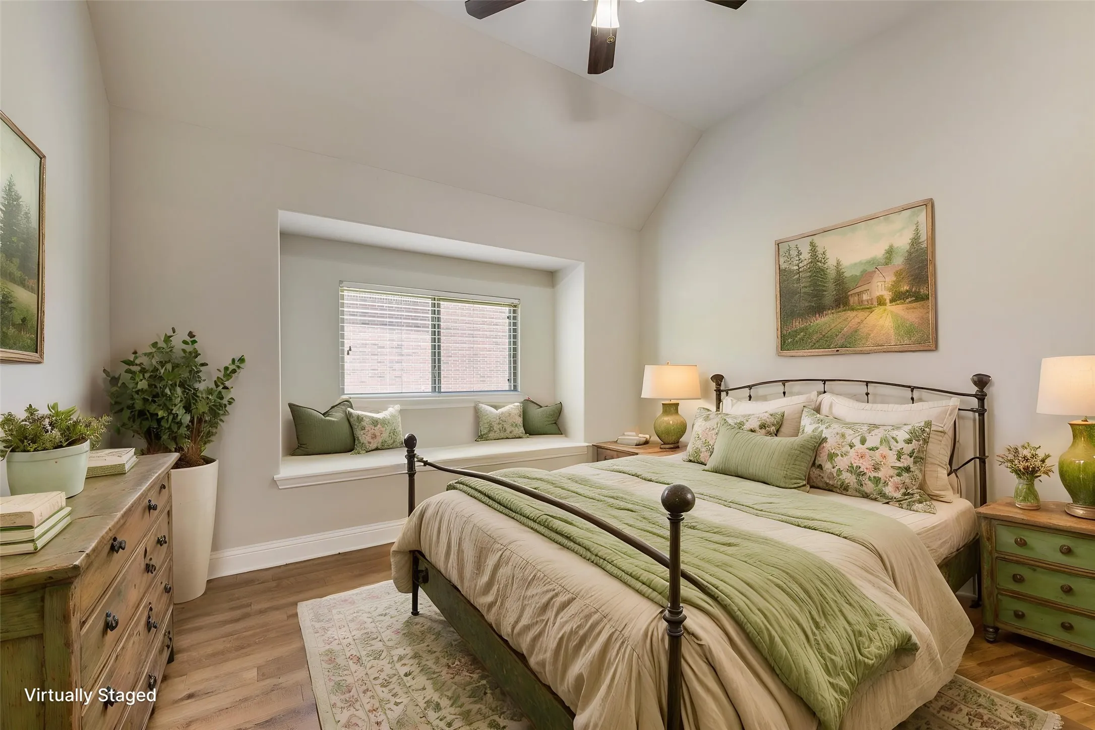 Virtually staged. Vaulted ceiling, ceiling fan, window seat with window, wood-finish flooring, and white painted walls