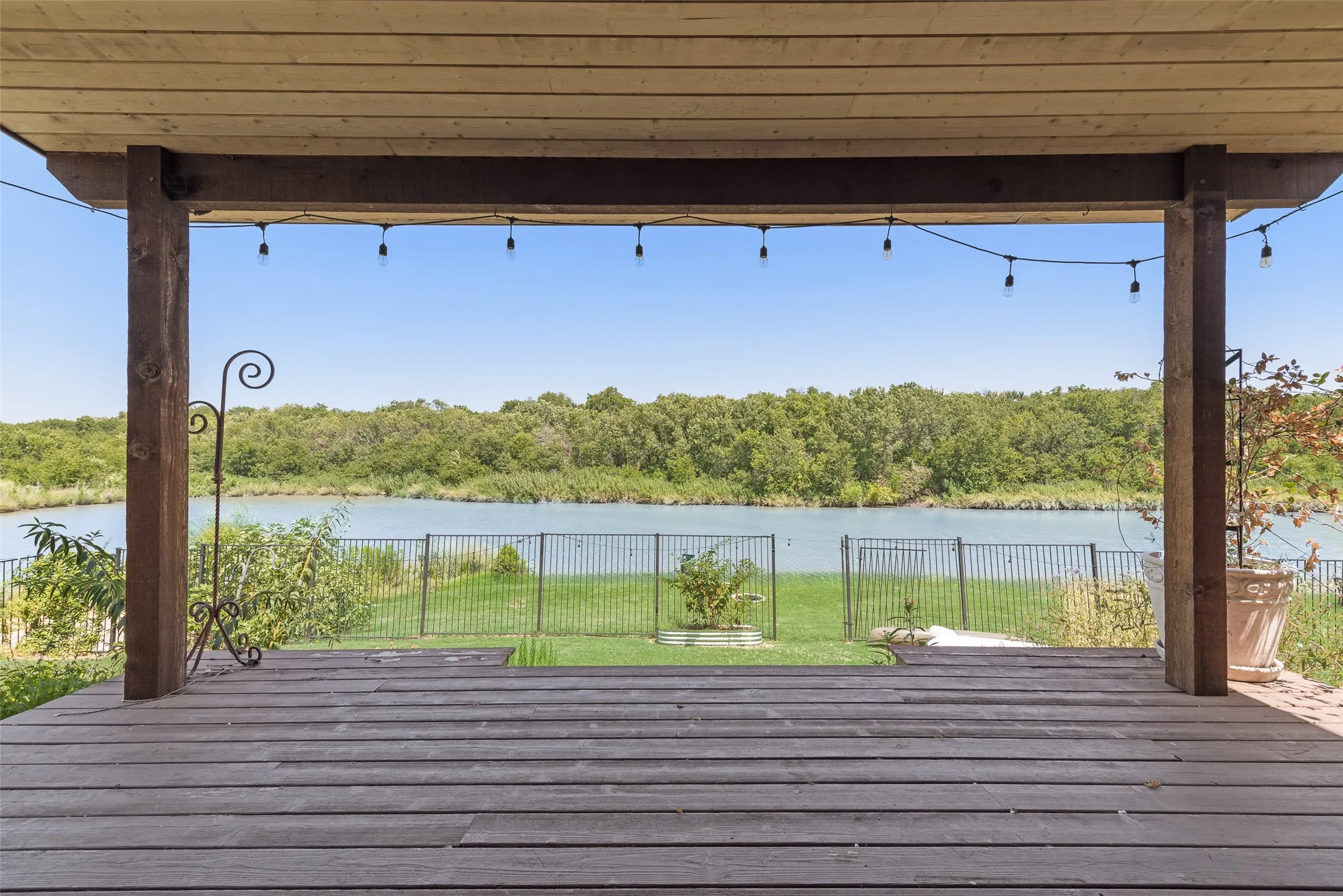 Virtually staged. Expansive covered patio featuring a wood-finish ceiling, exposed beams, brick exterior, and a built-in outdoor grill area