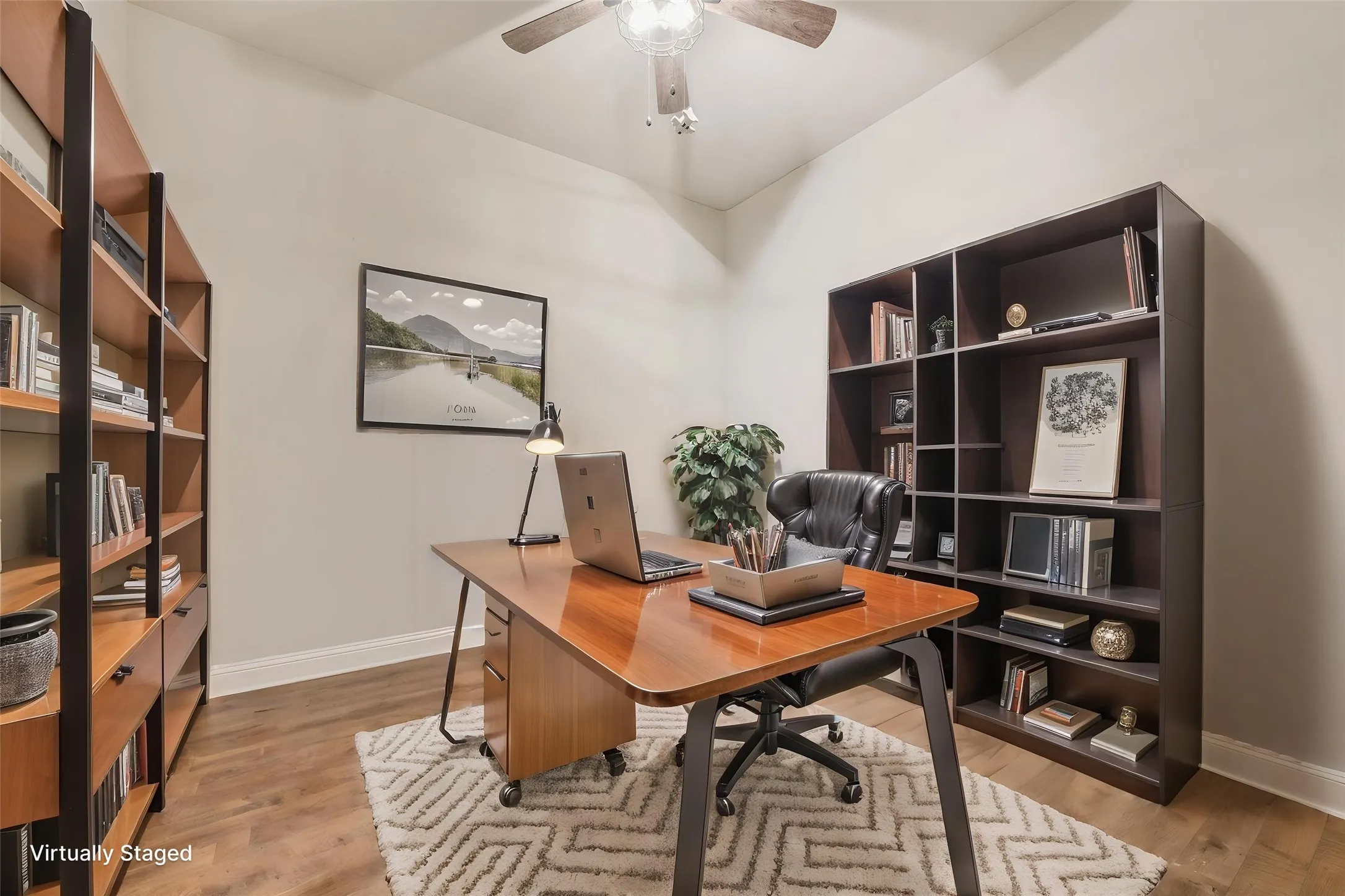 Virtually staged. Vaulted ceiling, wood-finish flooring, ceiling fan, and built-in shelving units