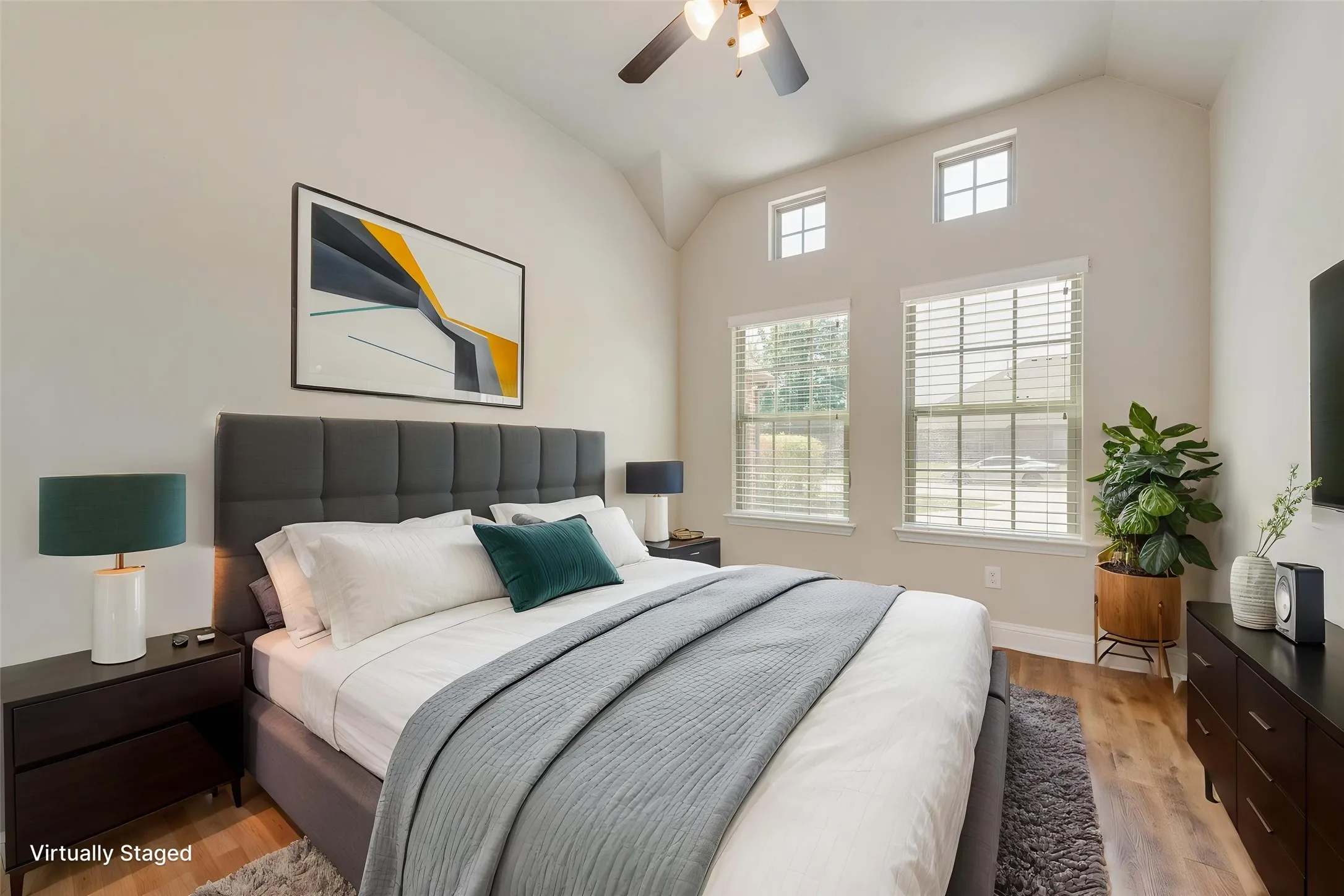 Virtually staged. Vaulted ceiling with a ceiling fan and recessed lighting, wood-finish flooring, and multiple windows with blinds
