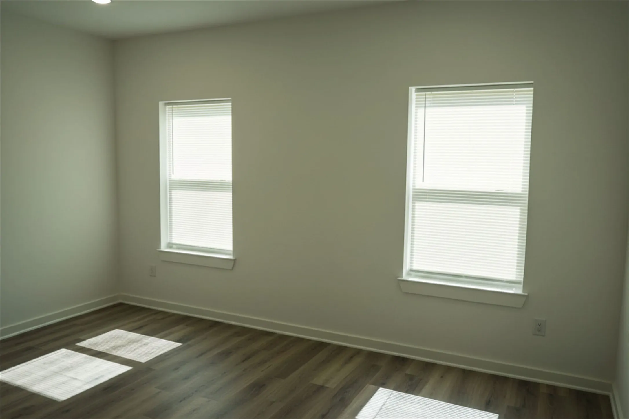 Recessed ceiling lighting, wood-finish flooring, and white trim