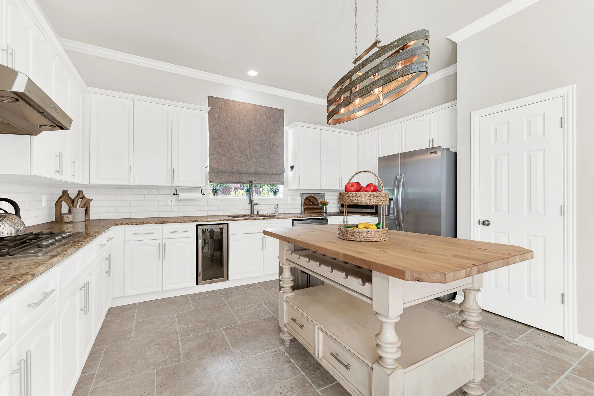 A subway tile backsplash sets off long prep counters lit by ambient downlighting near the window. You can easily whip up quick weeknight snacks while staying connected with guests.