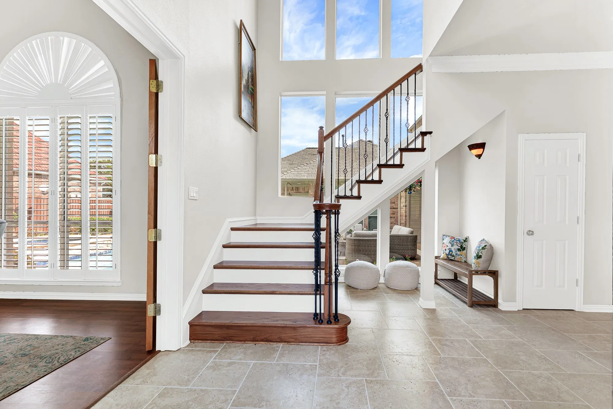 High upper windows bathe the grand entry in bright sky light while revealing glimpses of adjacent living spaces. You can greet arriving dinner guests warmly right as they step through the threshold.