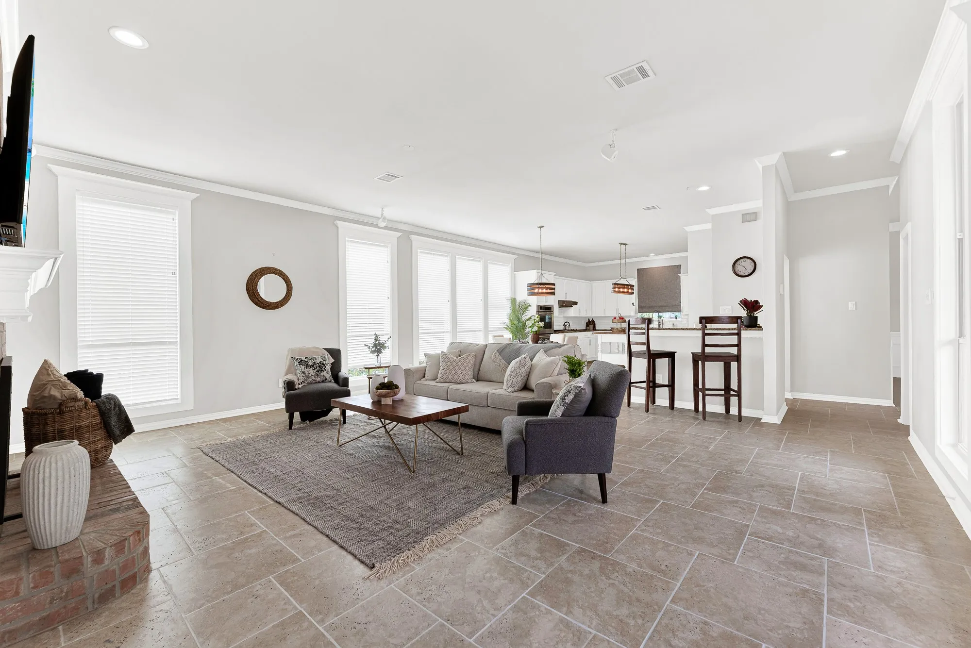 Tall windows stretch along the side wall, bouncing outdoor light clear through to the adjacent breakfast counter. Family can easily gather for game night while keeping conversation flowing into the kitchen.