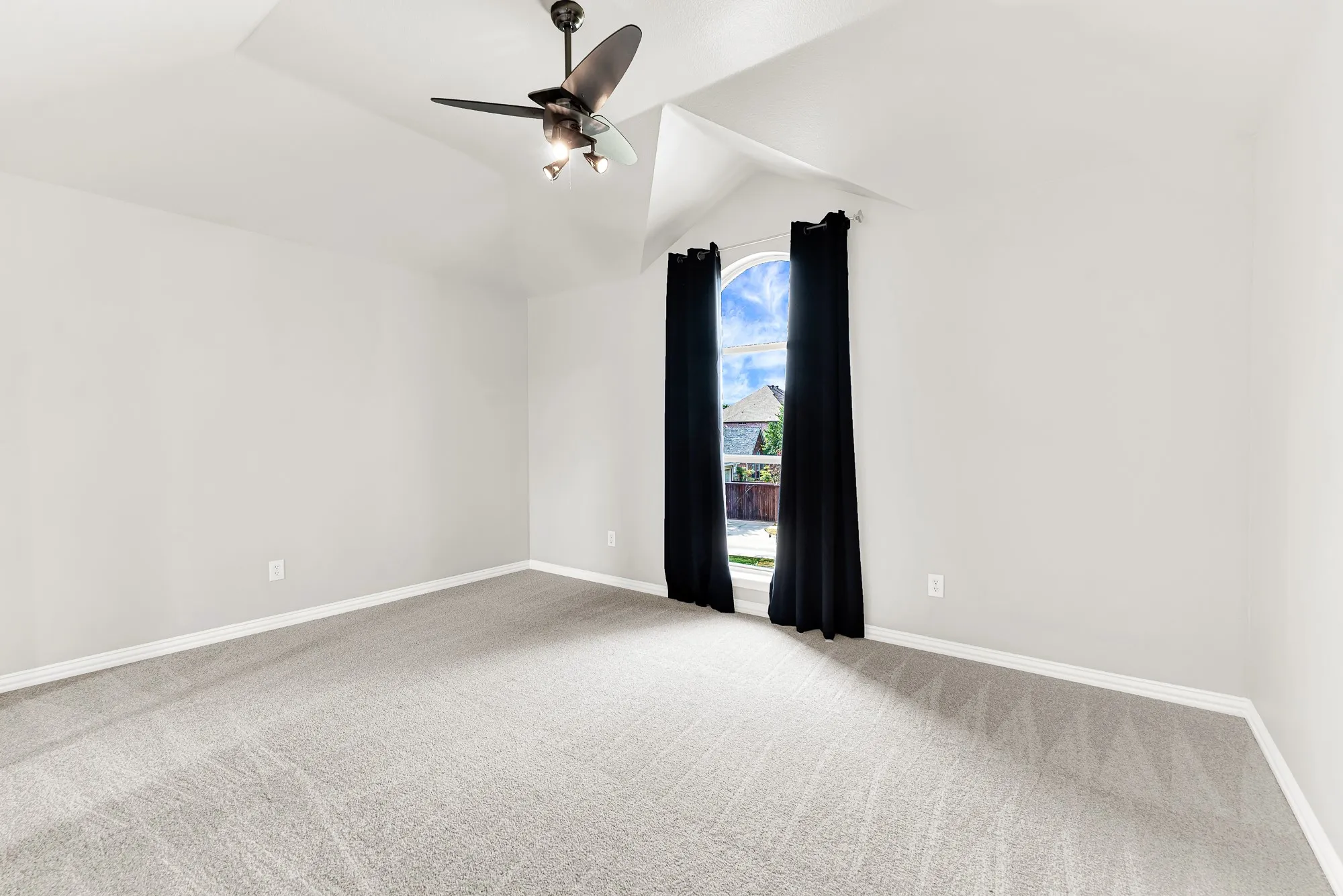 An elegant arched window alcove creates a dramatic focal point beneath sloped ceiling lines. Teenagers can comfortably lounge while listening to music or reading under soft afternoon sun