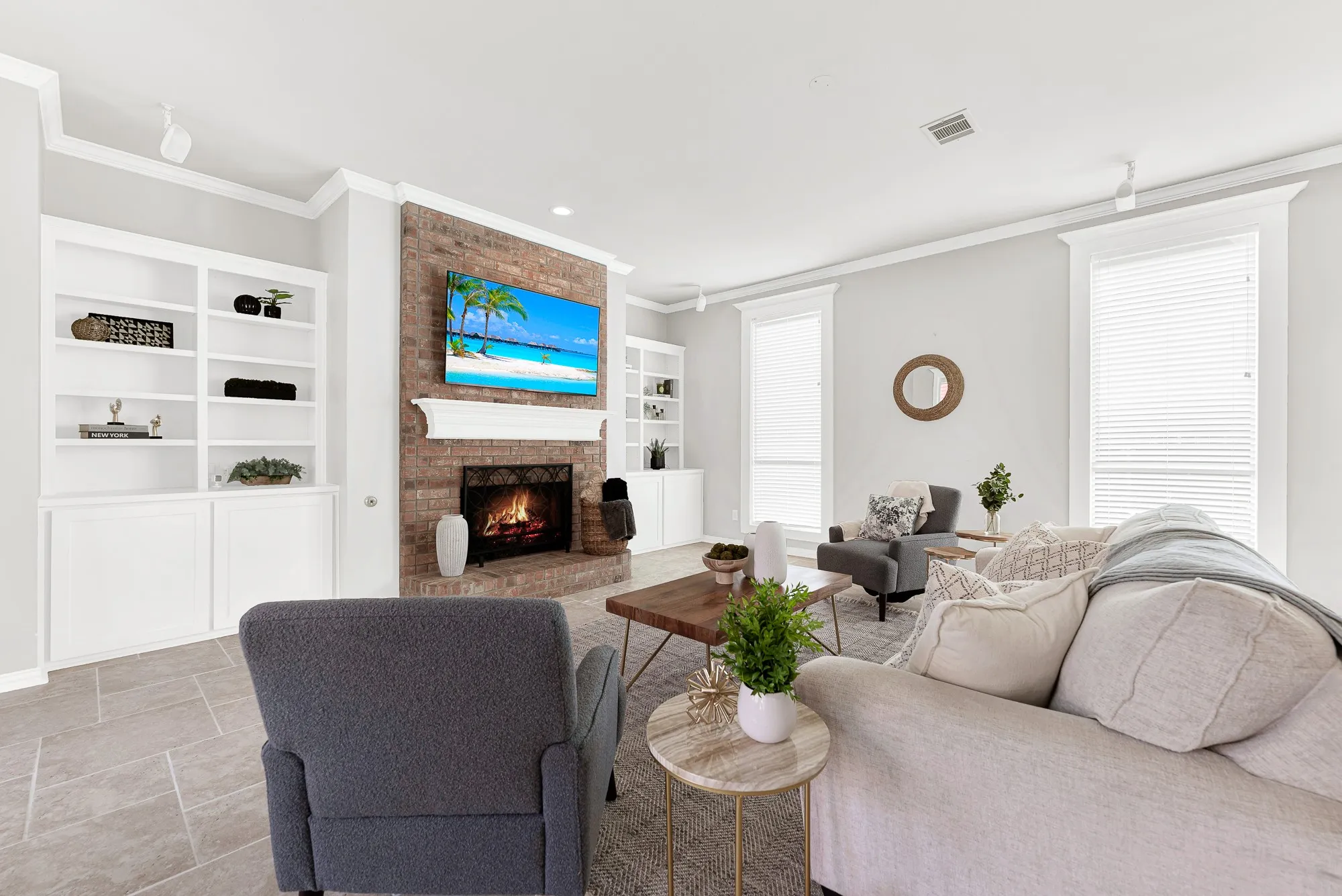 Clean white trim and flush shelving frame the central brick fireplace against crisp, neutral walls. You can host casual weekend watch parties with everyone comfortable in one central hub.