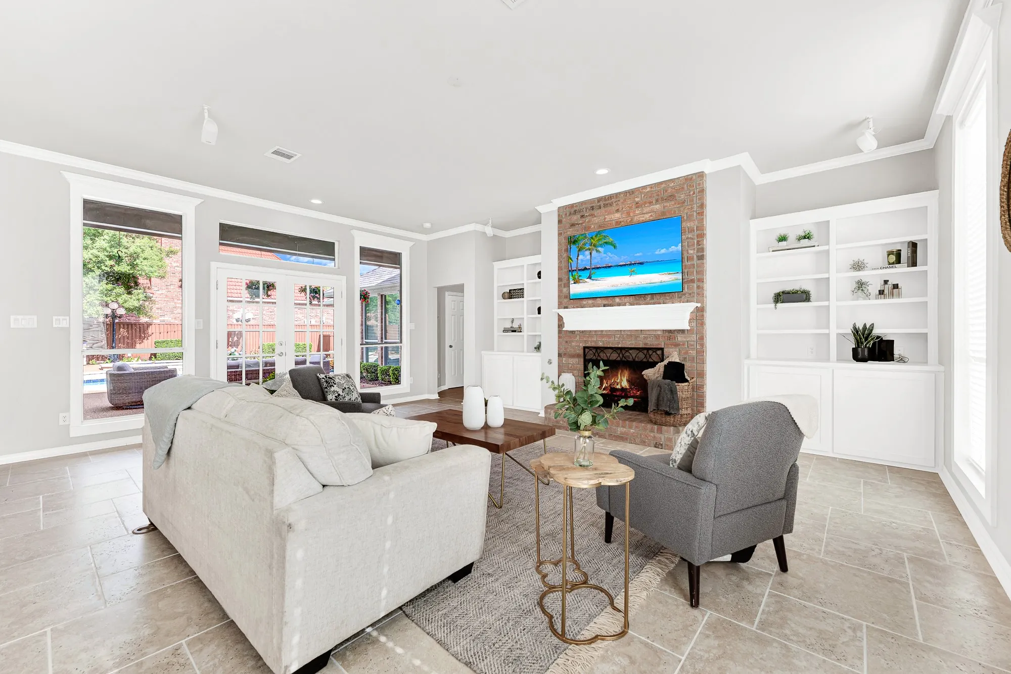 A red brick hearth flanked by built-in shelving anchors the main wall under soft track lighting. You can unwind by a crackling fire on cool evenings after spending hours swimming outside.
