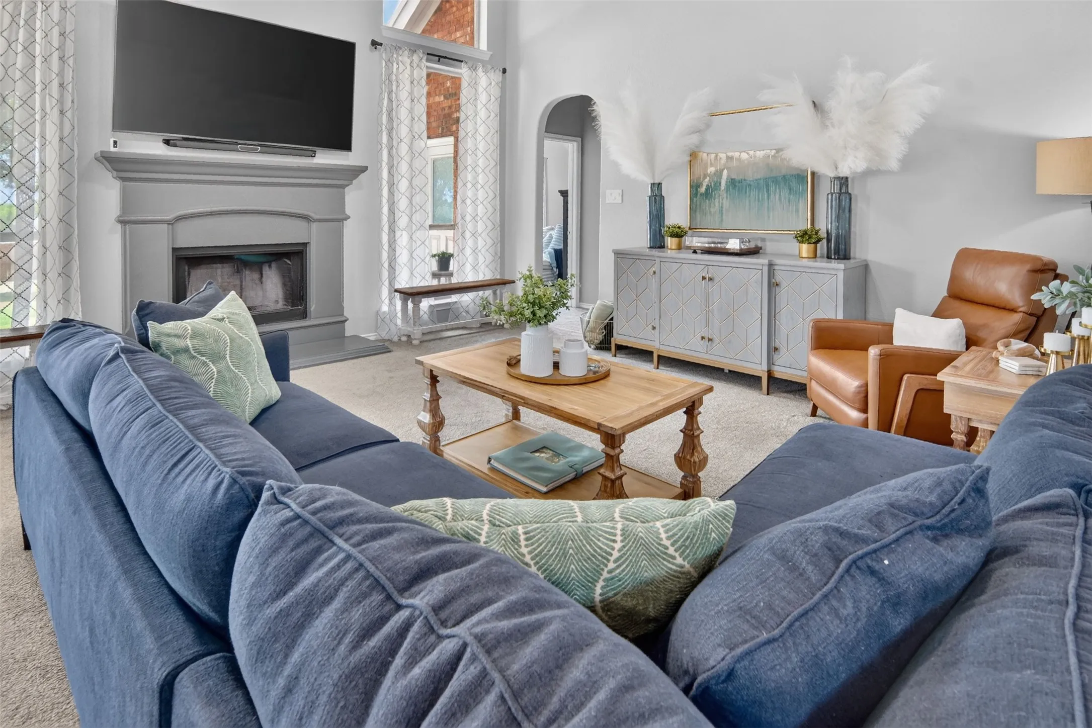spacious living with soaring ceiling, floor ceiling windows, wood burning fireplace