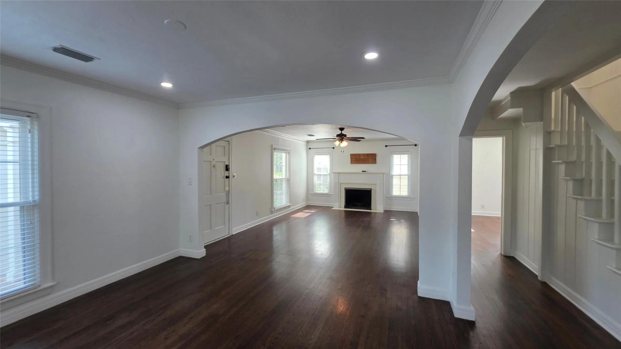 Spacious living room with wood-burning fireplace and a ceiling fan.
