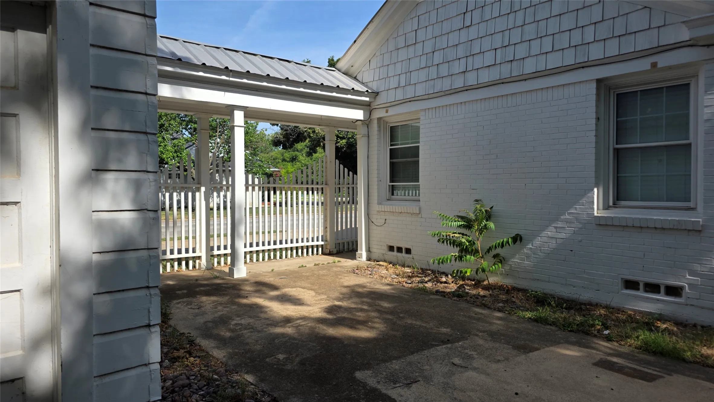 This covered walkway connects the house and detached garage. Open back patio ready for your own outdoor decor!