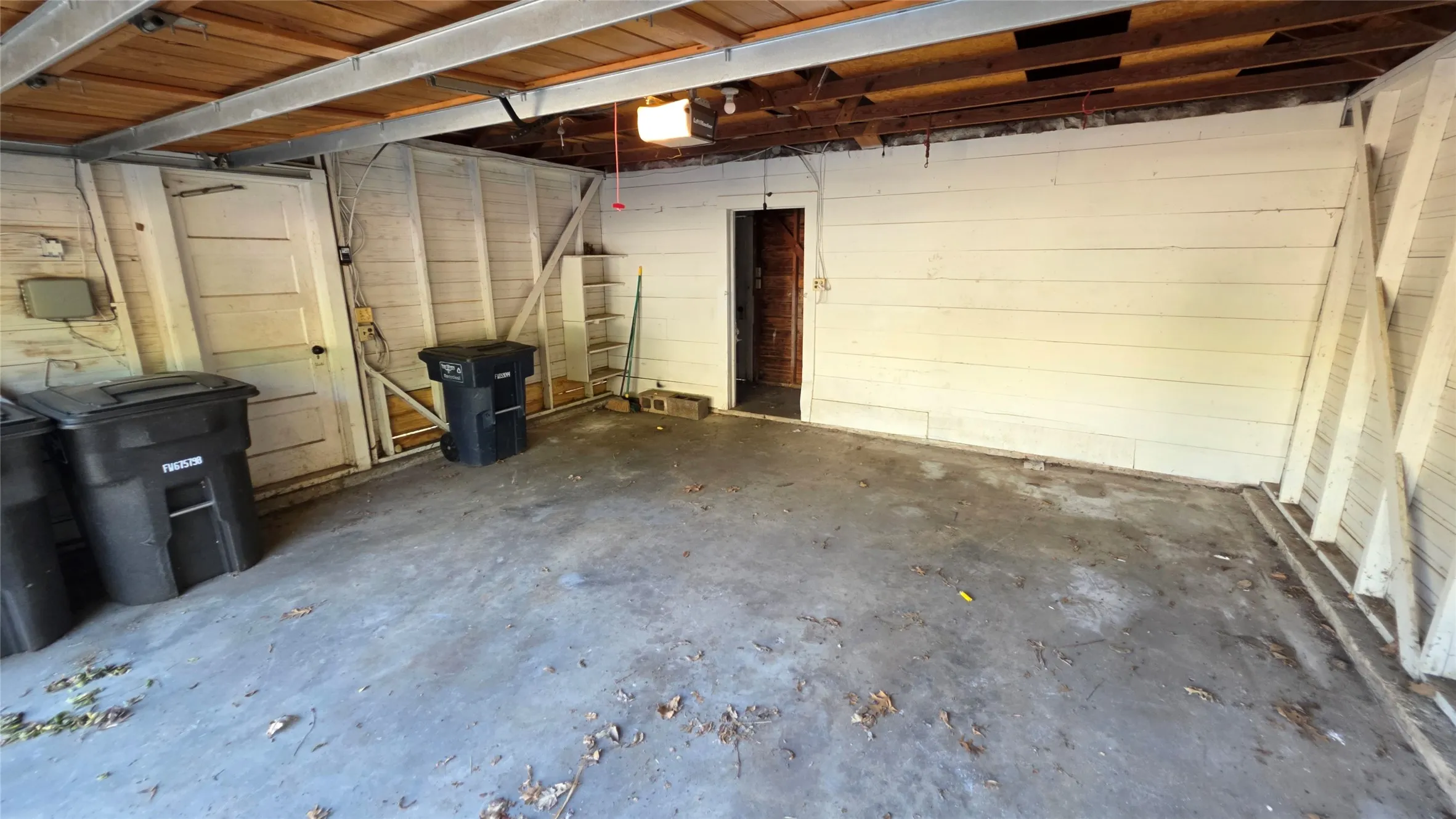 Two-car garage has an electric opener, built-in shelves, and a storage room.
