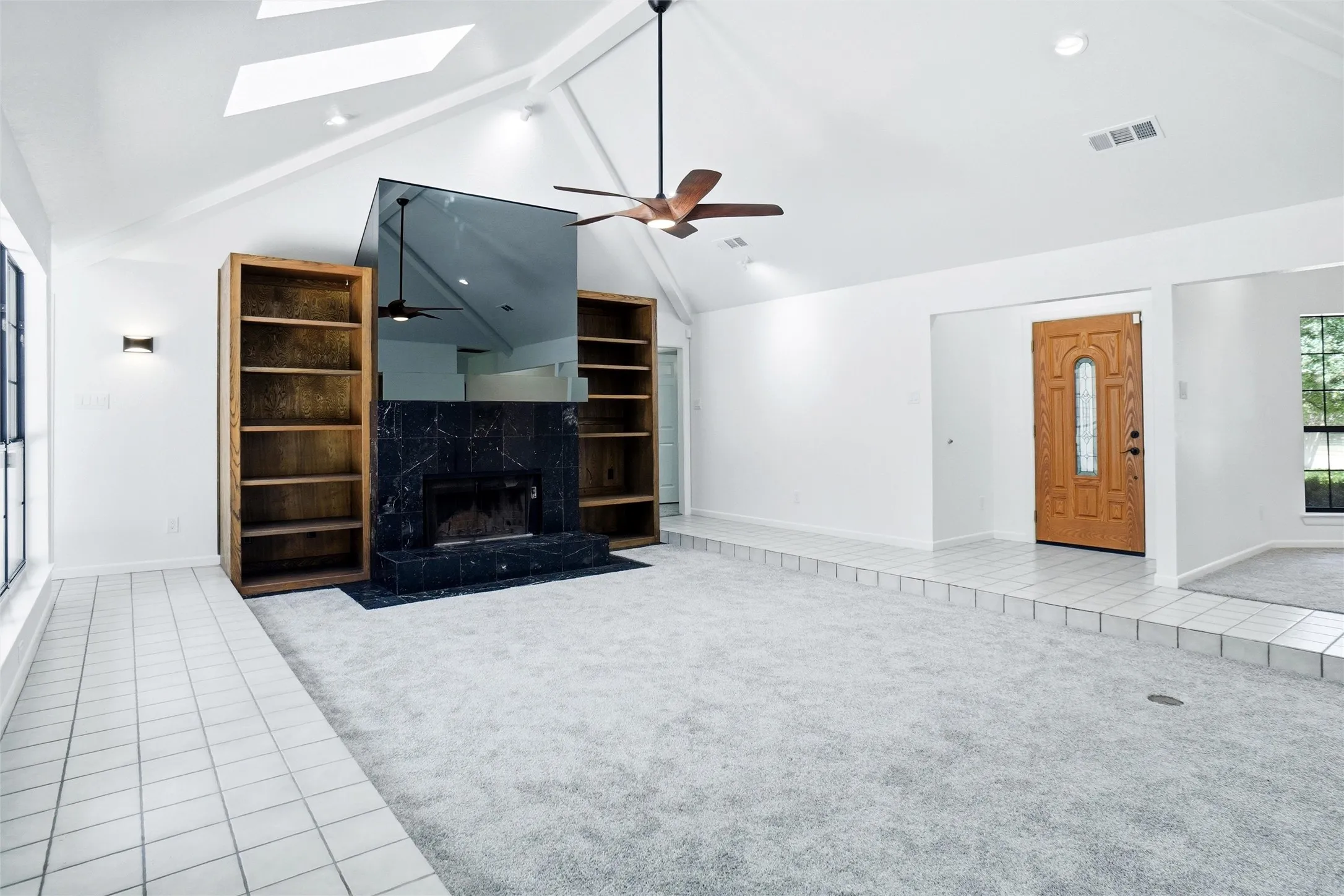 Stunning floor-to-ceiling fireplace featuring custom built-in shelving, perfect for display and storage.