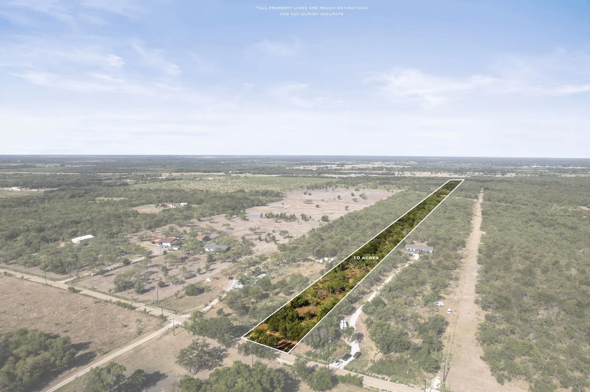 Expansive rural acreage featuring a verdant tree line and marked property boundaries