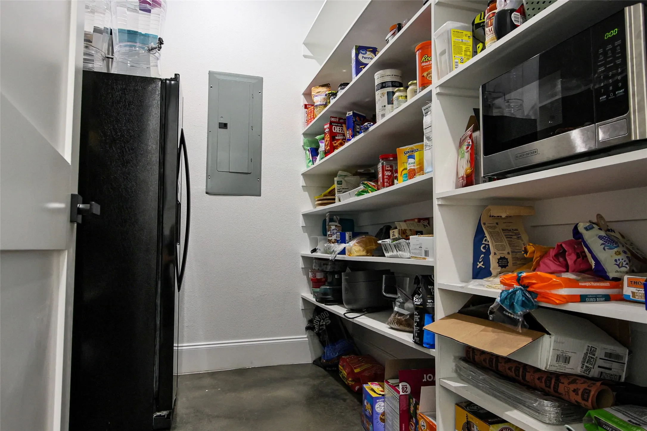 Custom built-in shelving, white wall paint, and concrete-finish flooring