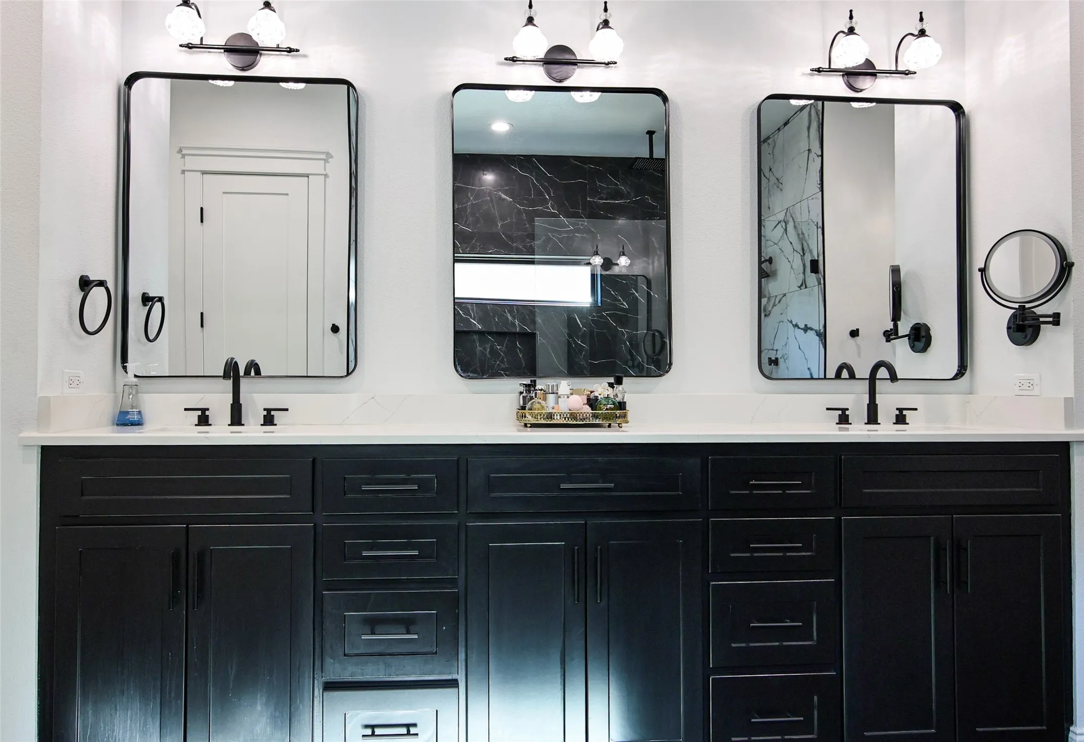 Dual vanity with black cabinetry, white countertop, individual mirrors, and matte black fixtures