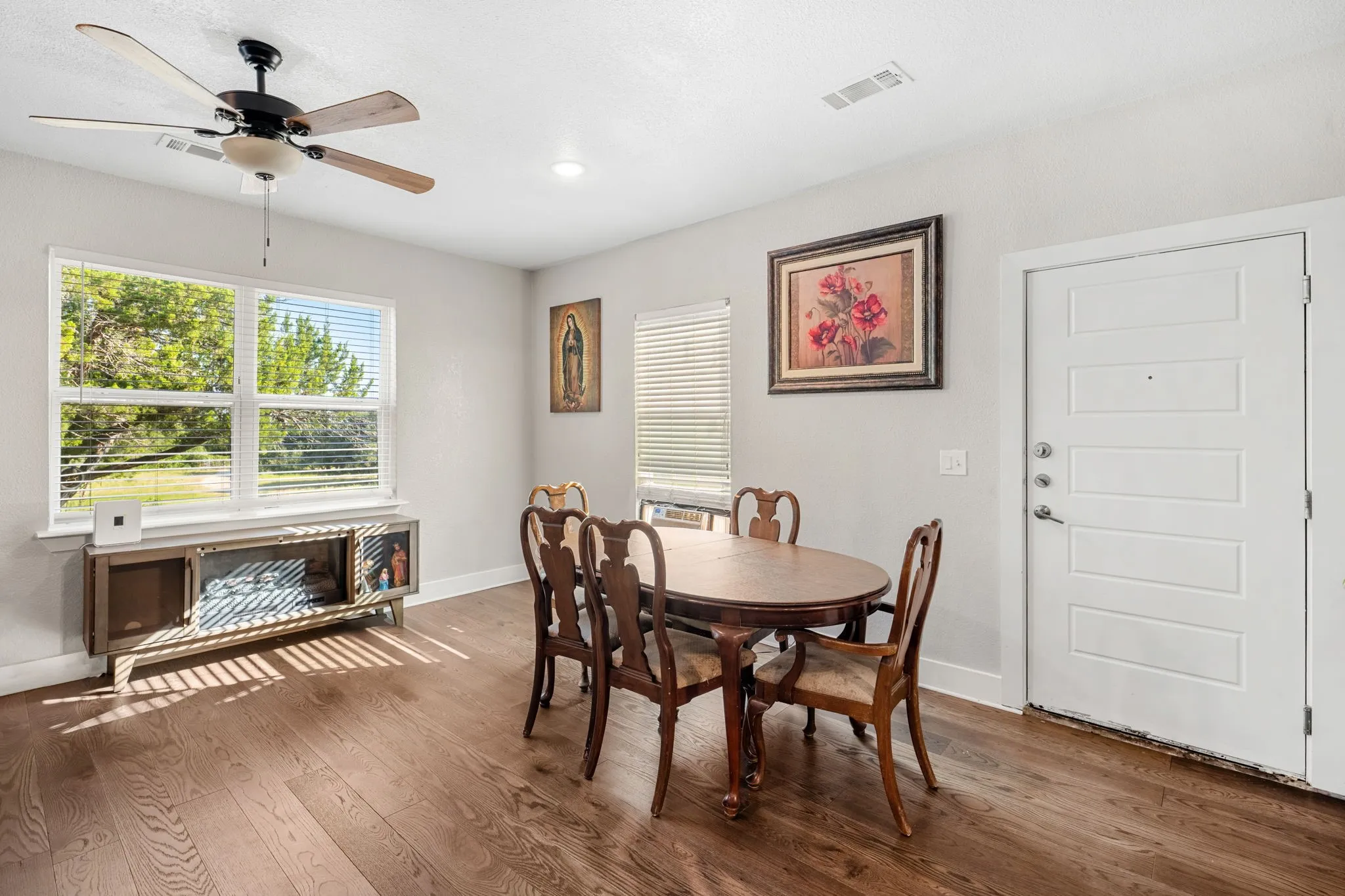 Wood-finish flooring with a ceiling fan light fixture, recessed lighting, and a white paneled door