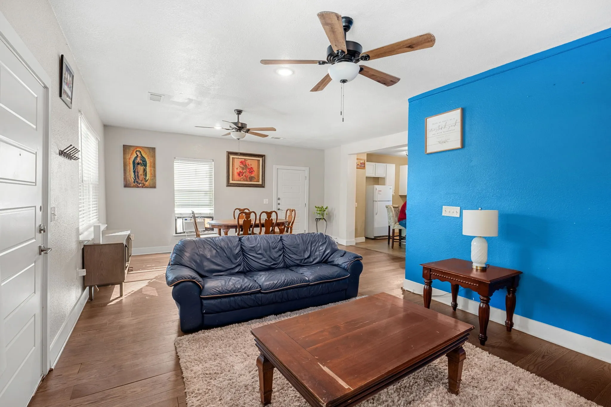 Wood-finish flooring throughout, bright white walls, and a vibrant accent wall