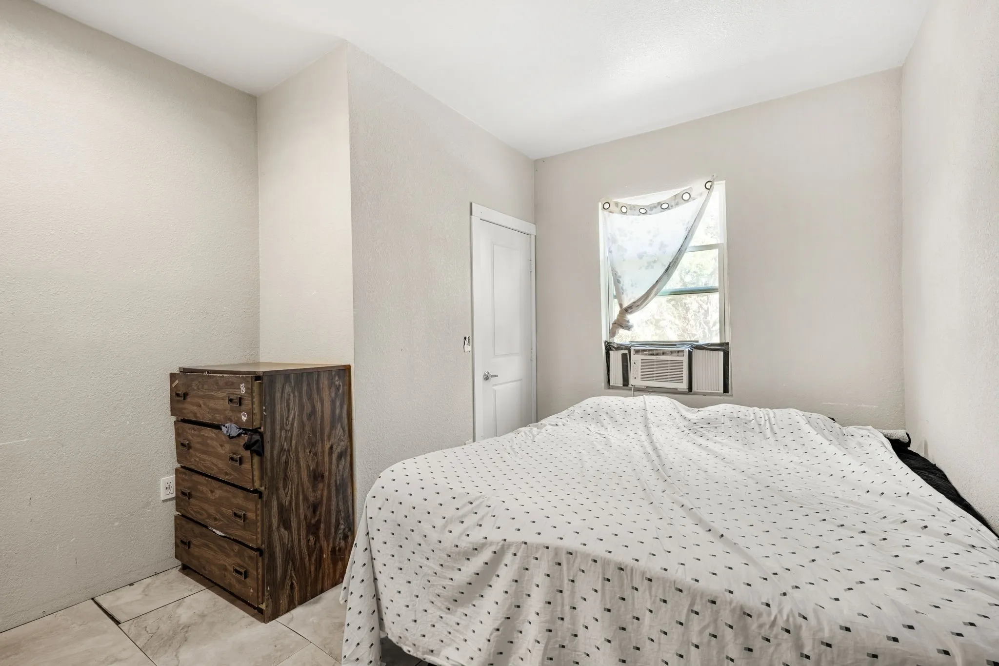 Light-toned walls with a window-mounted air conditioning unit